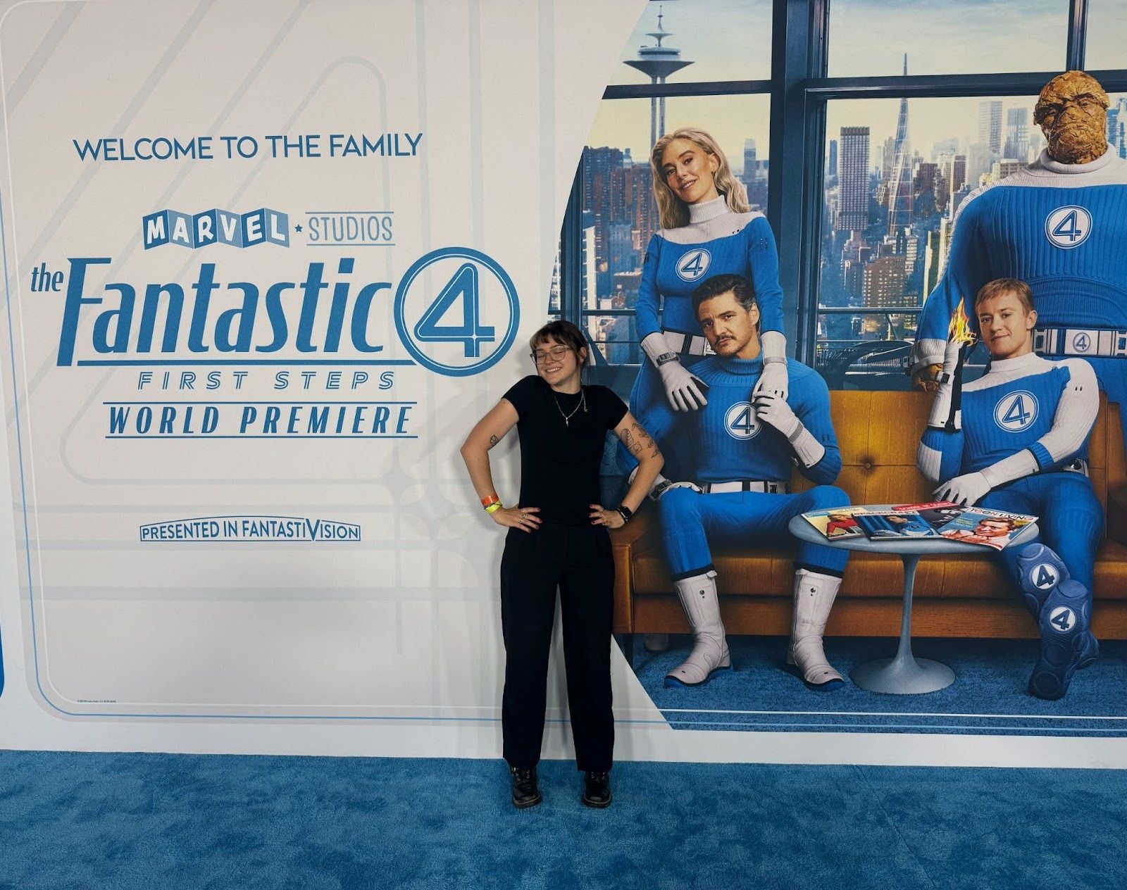 Emmy stands on a blue carpet in front of a Fantastic Four movie premiere billboard.