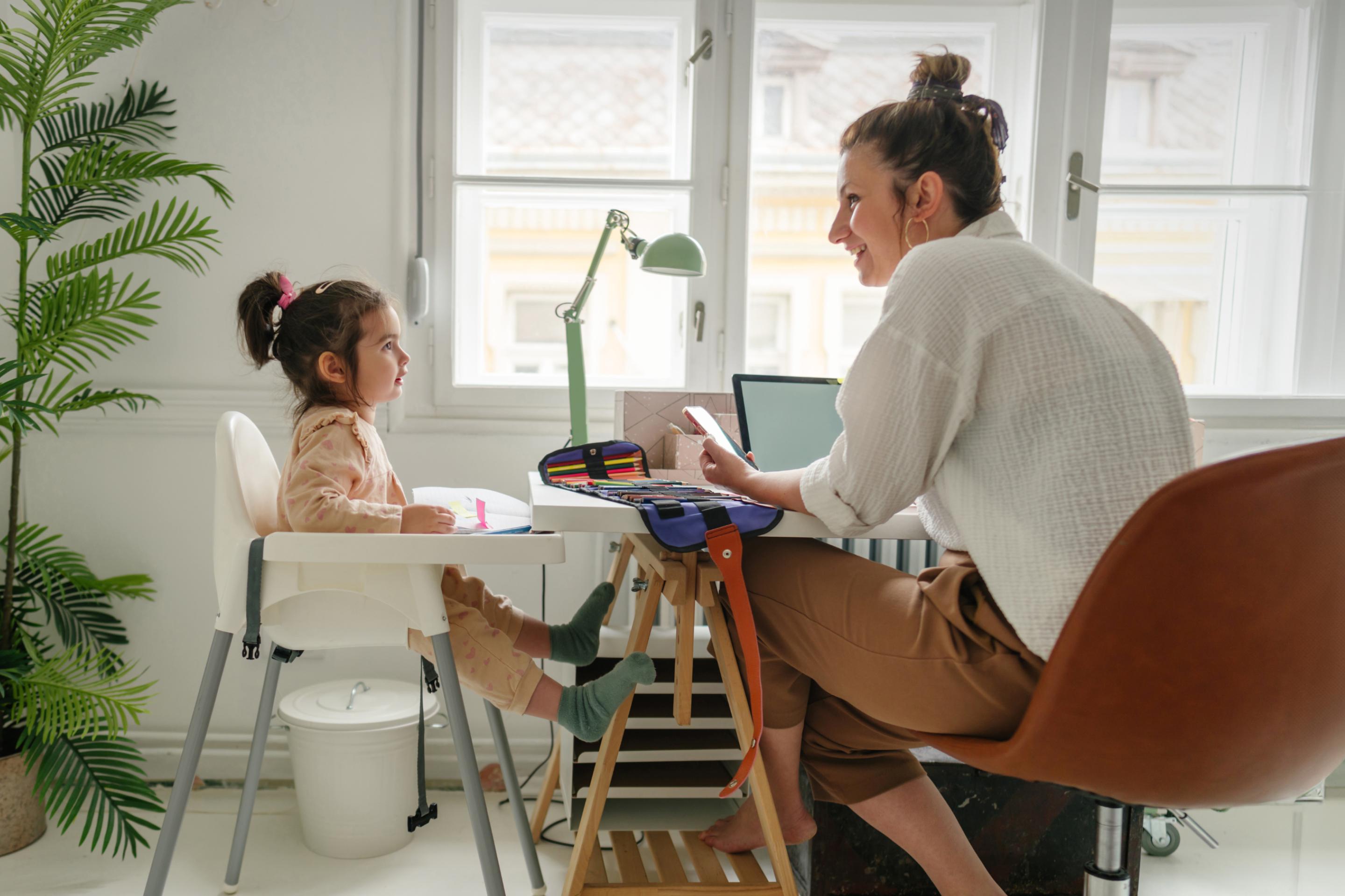 Woman taking care of baby while doing home office, illustrating Canada maternity leave.