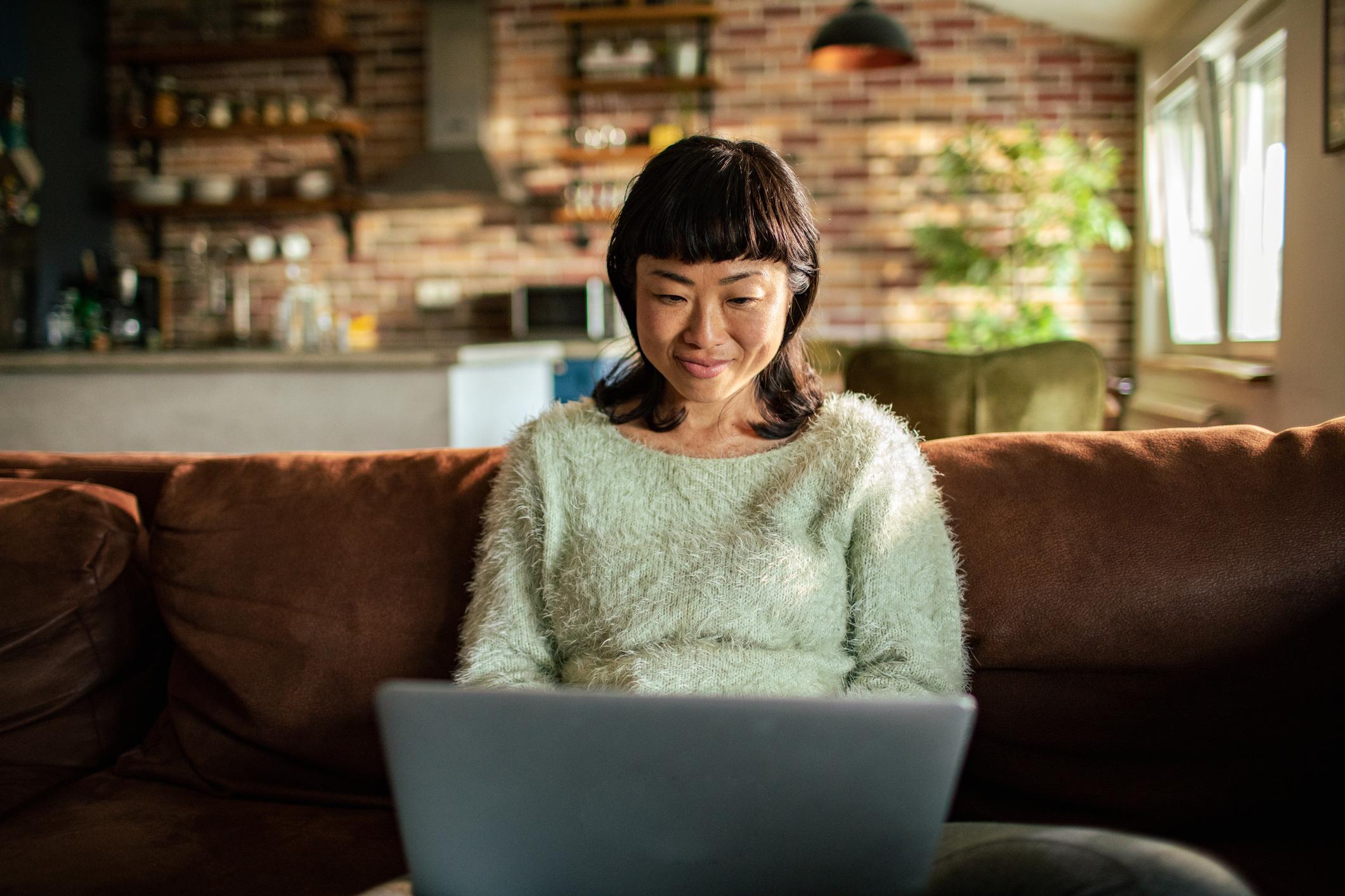 Woman accepts payment in crypto on her laptop at home