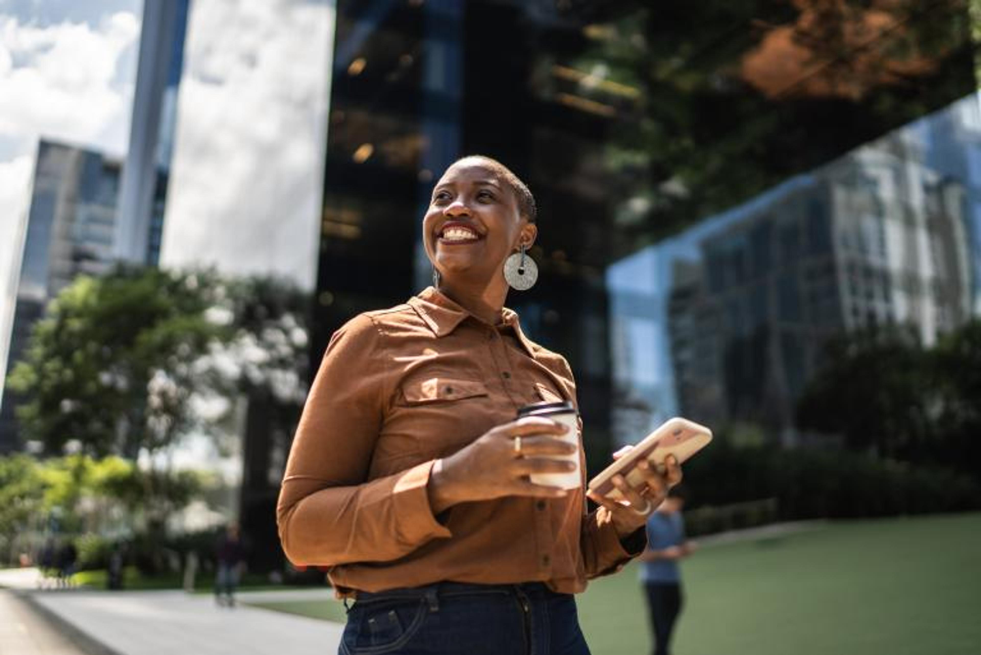 Professional on their phone holding a coffee