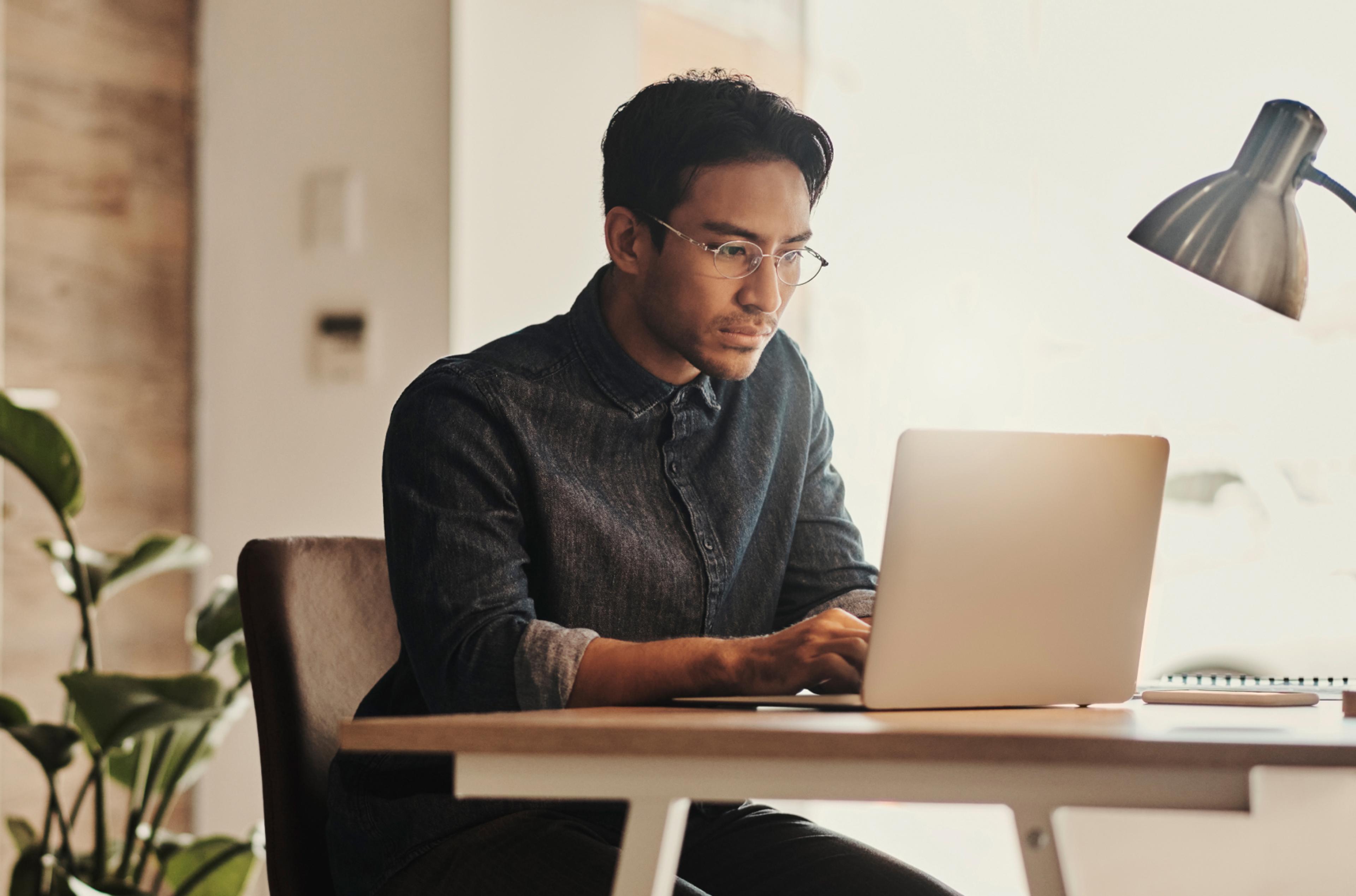 Remote employee works on his laptop from home