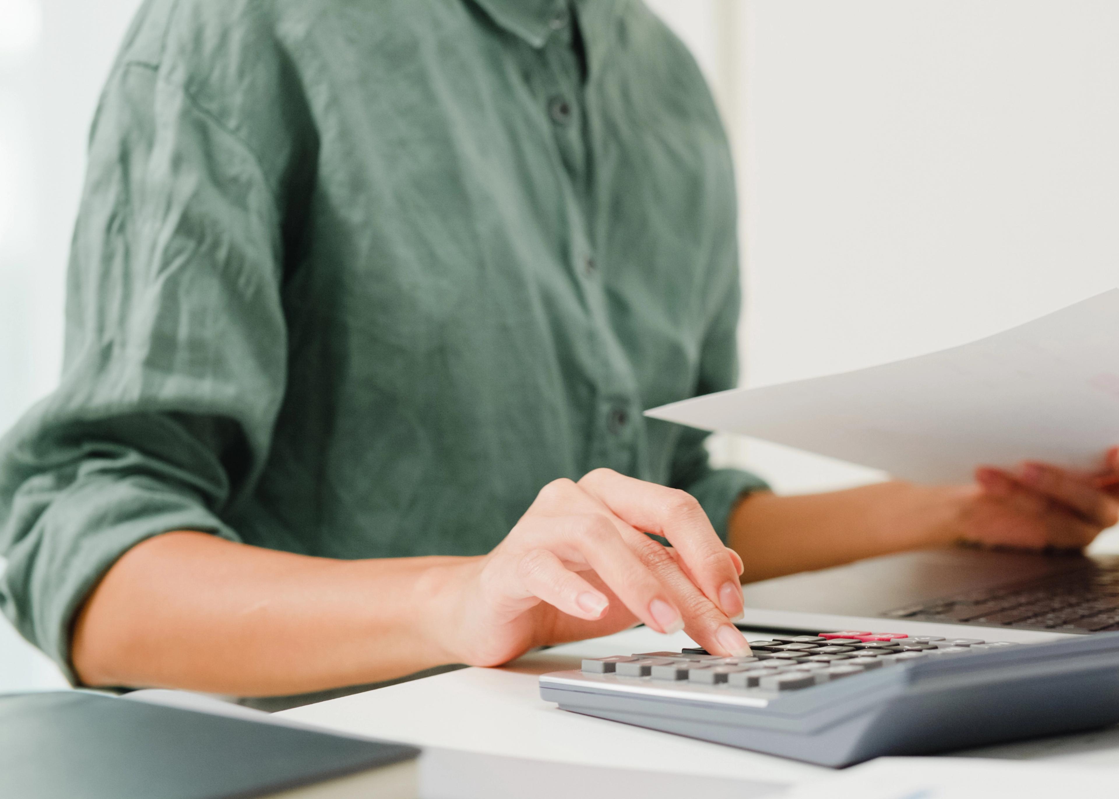 Business owner sitting at computer performing payroll audit