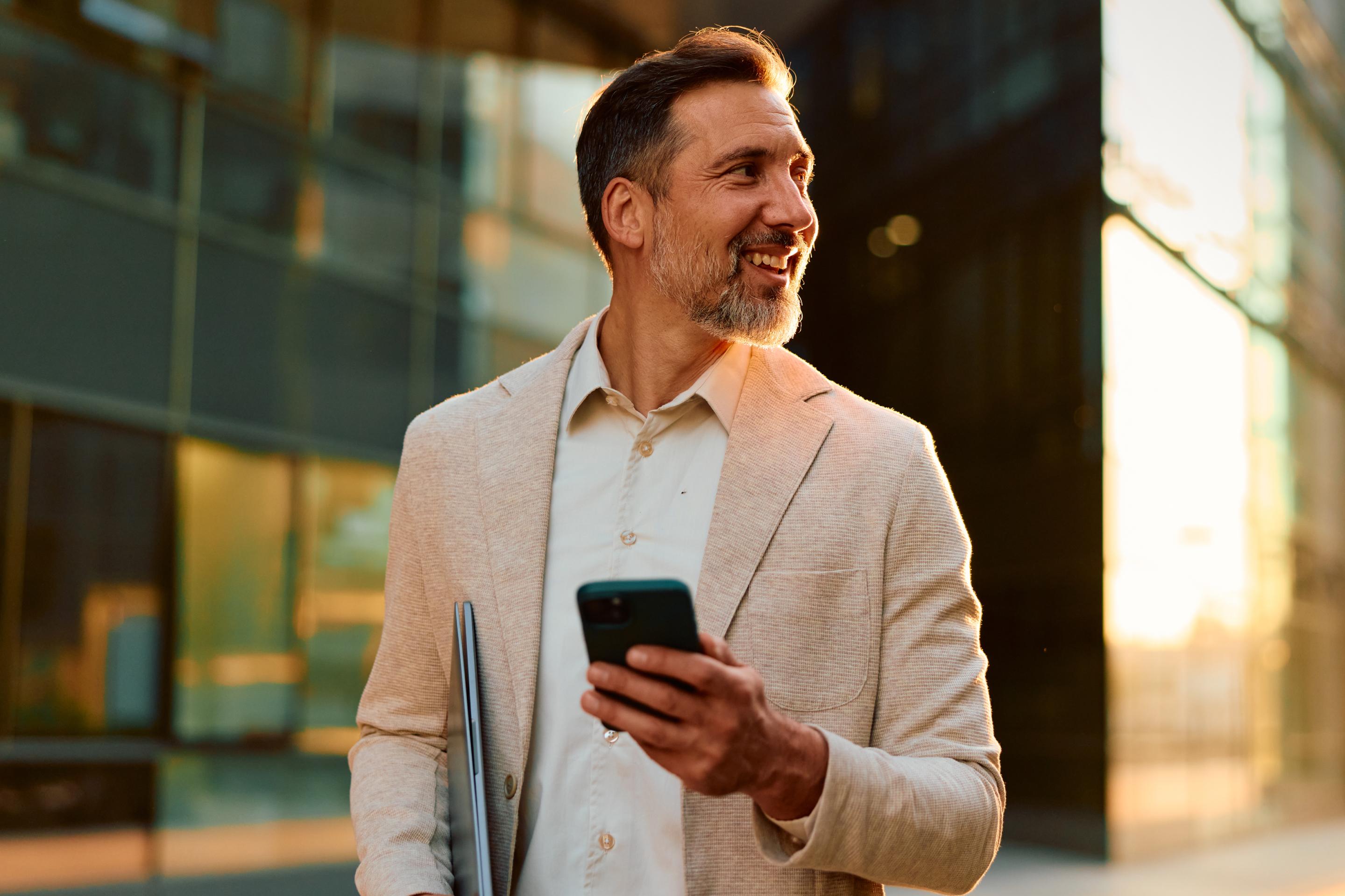 Businessman walking to the office with a phone, representing a typical earner of the average salary in Spain