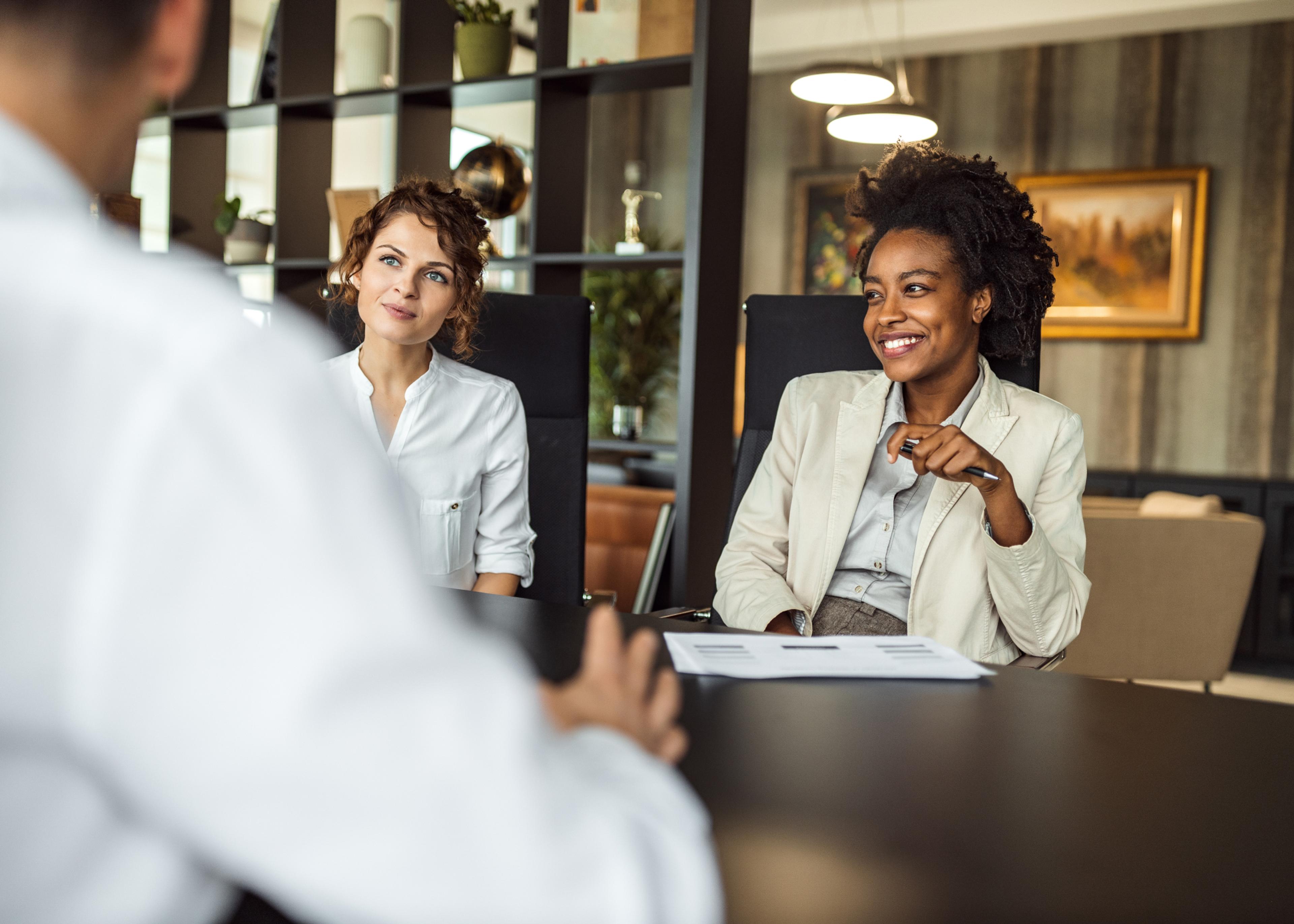 Small HR team collaborating around a table in an office conference room
