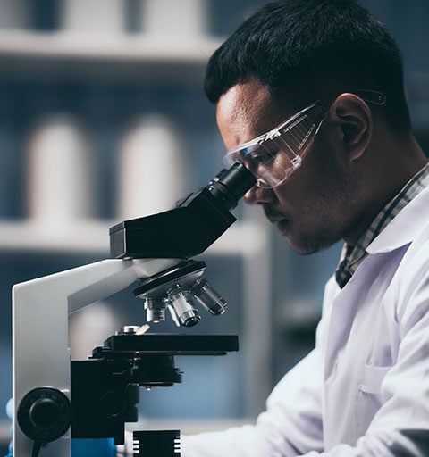 Scientist looking into a microscope