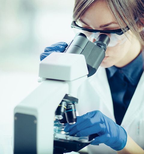 Scientist looking into a microscope