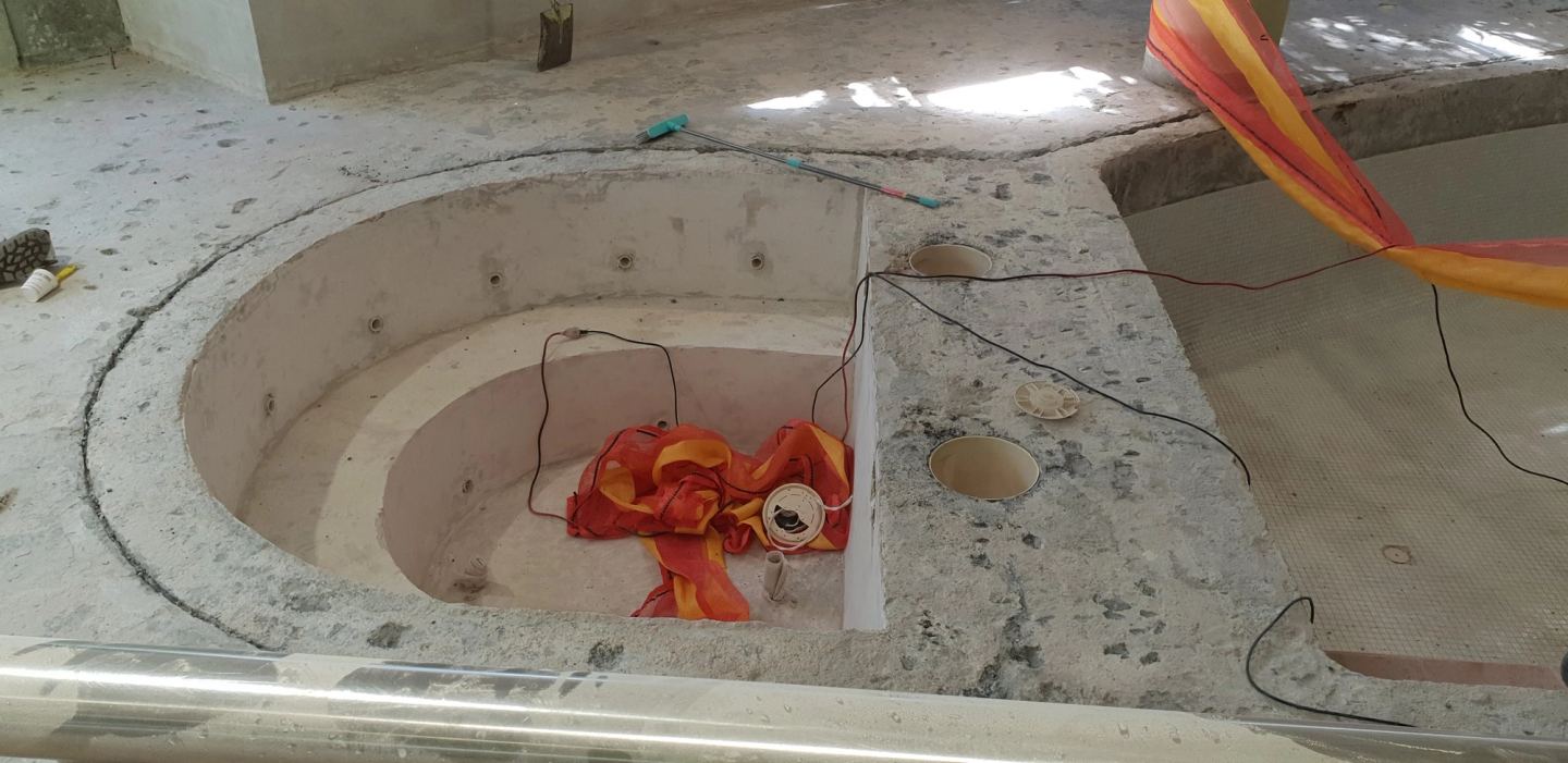 The spa demolished back to its concrete shell with services exposed