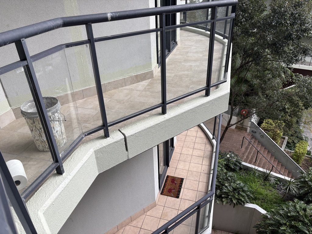 A completed curved balcony, newly tiled, with the glass balustrade reinstated