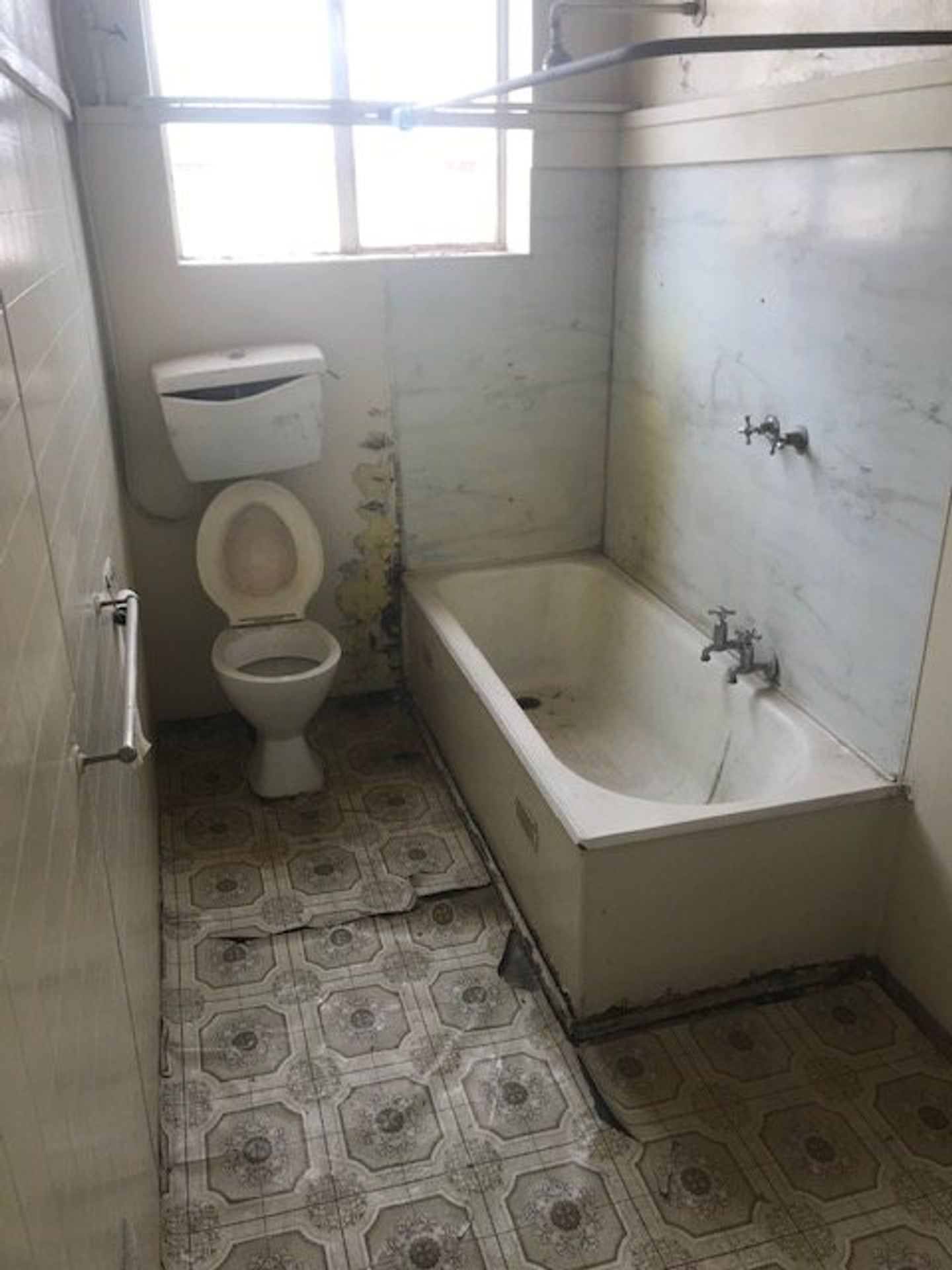 An existing apartment bathroom at the end of its serviceable life, fittings failing
