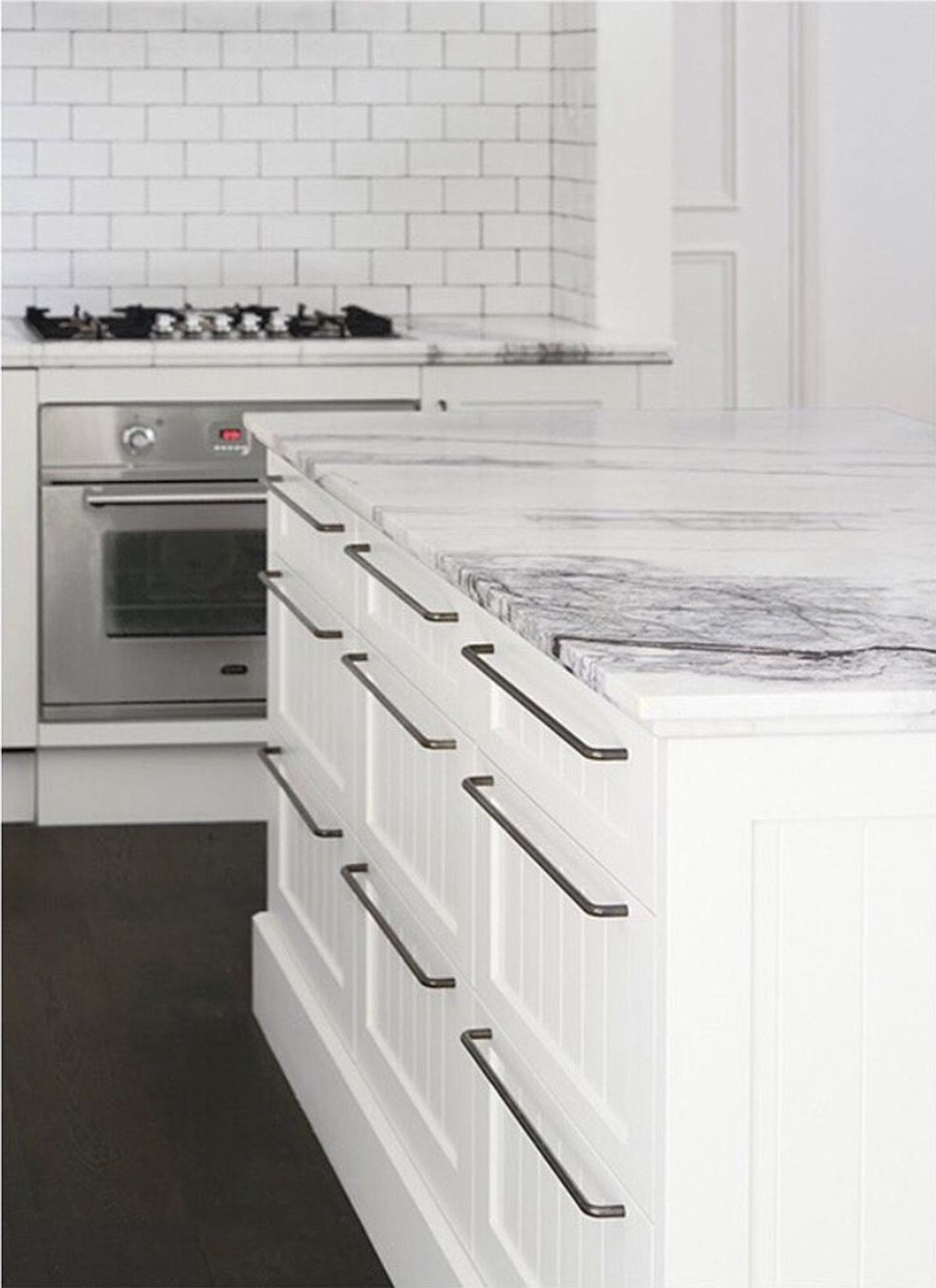 A marble benchtop over shaker joinery with a stainless oven and gas cooktop