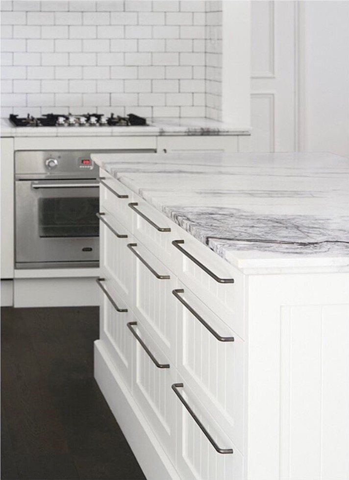 A marble benchtop over shaker joinery with a stainless oven and gas cooktop