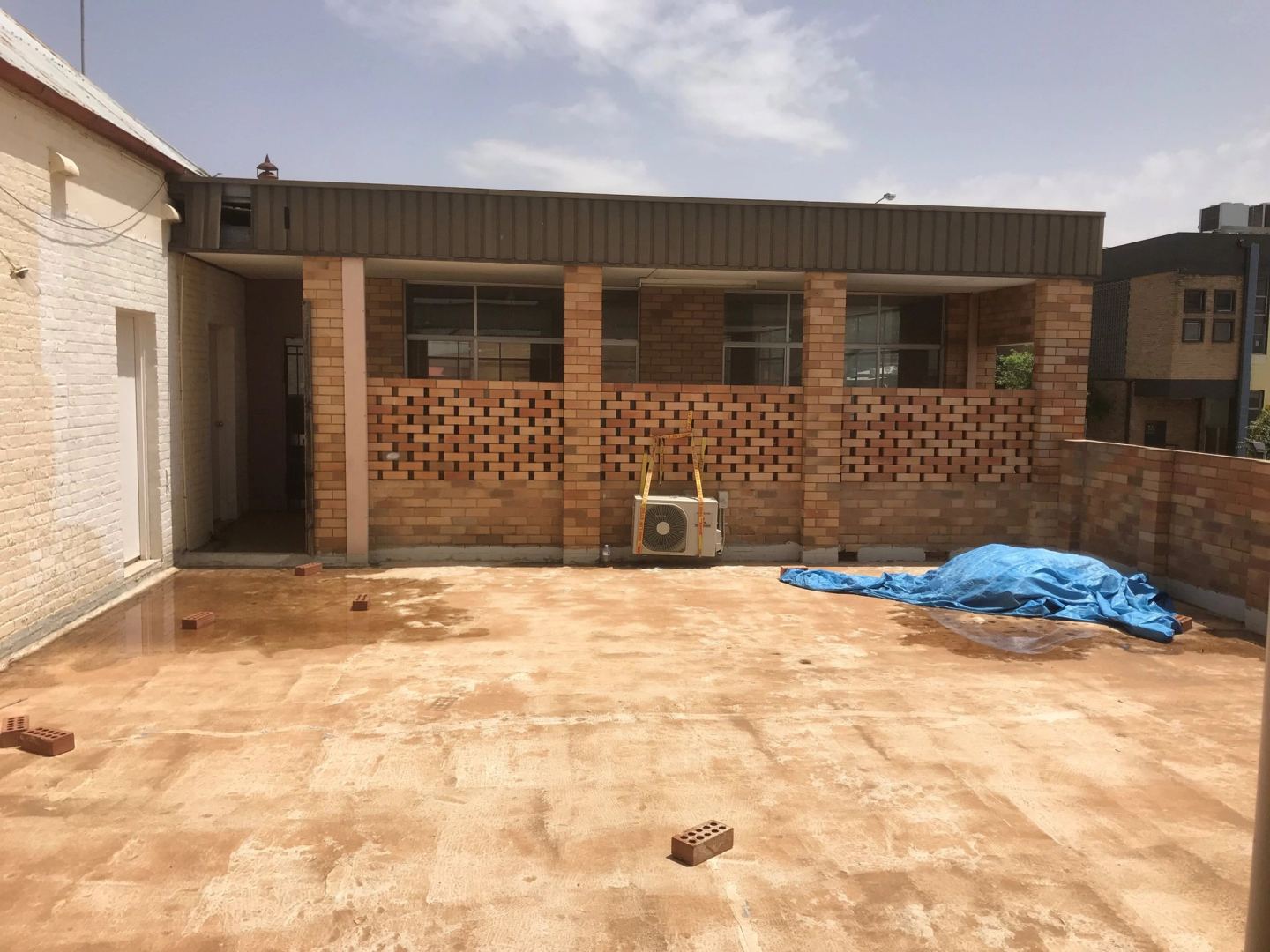 The rear courtyard before works, a bare dirt yard enclosed by original brickwork