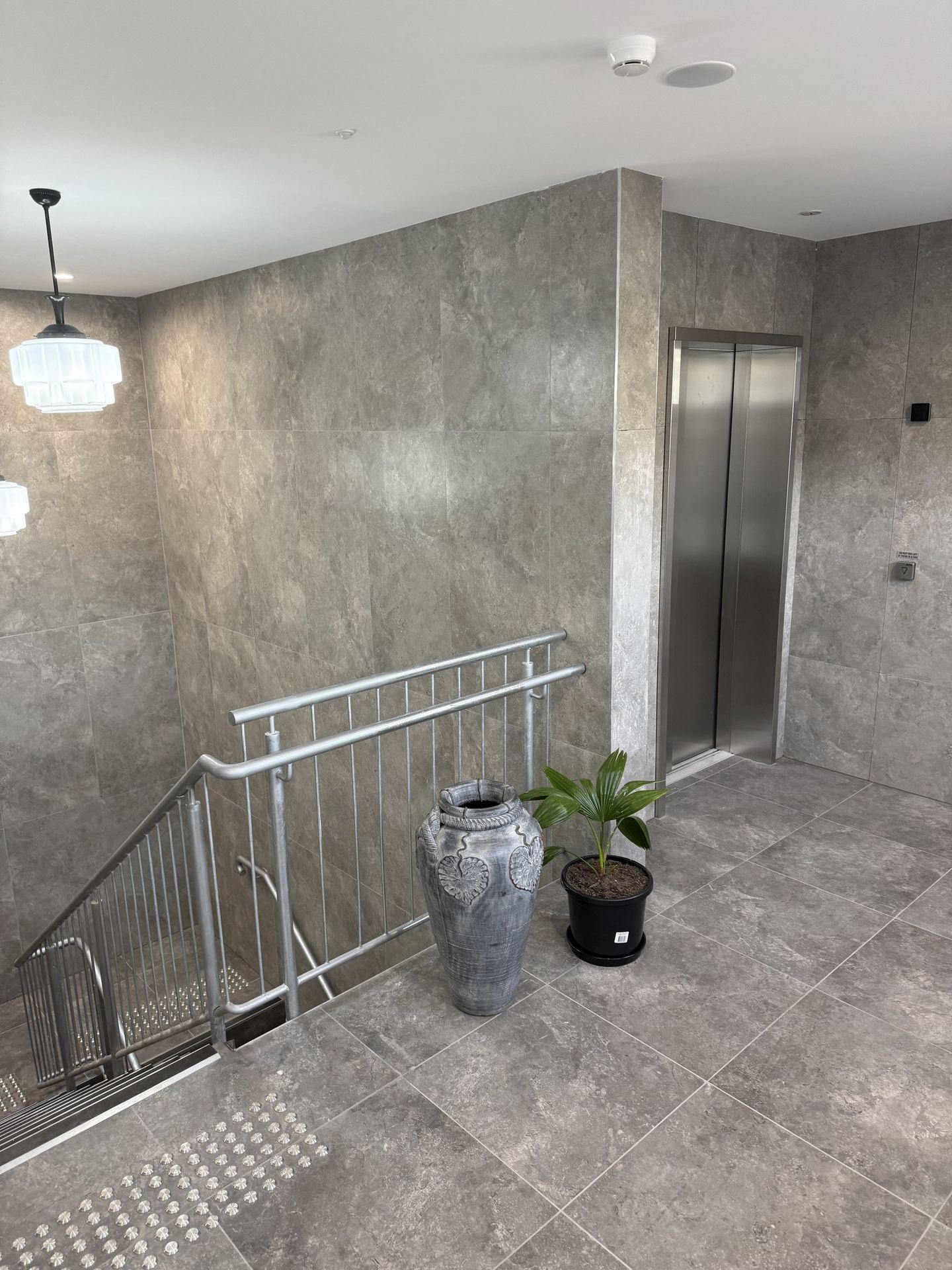 The first-floor foyer with the new lift and tactile indicators at the stair head