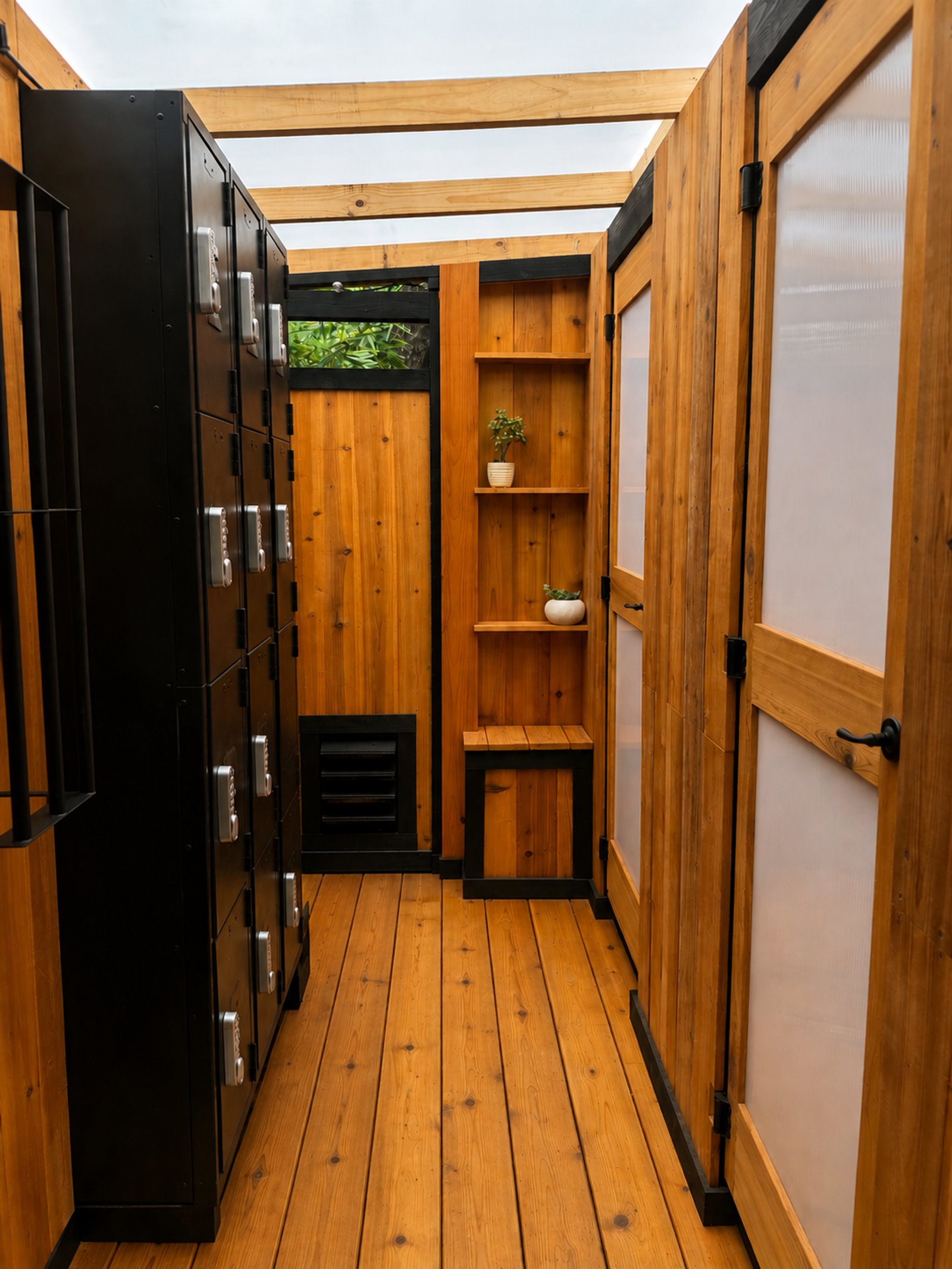 A modern changing room with wooden walls, floor, and translucent-paneled doors, plus a row of black lockers.