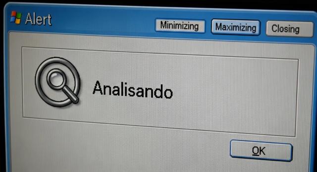 Captura de tela de uma janela de alerta com os botões 'Minimizar', 'Maximizar' e 'Fechar' no topo. A janela exibe um ícone de lupa com o texto 'Analisando' e um botão 'OK' no canto inferior direito.