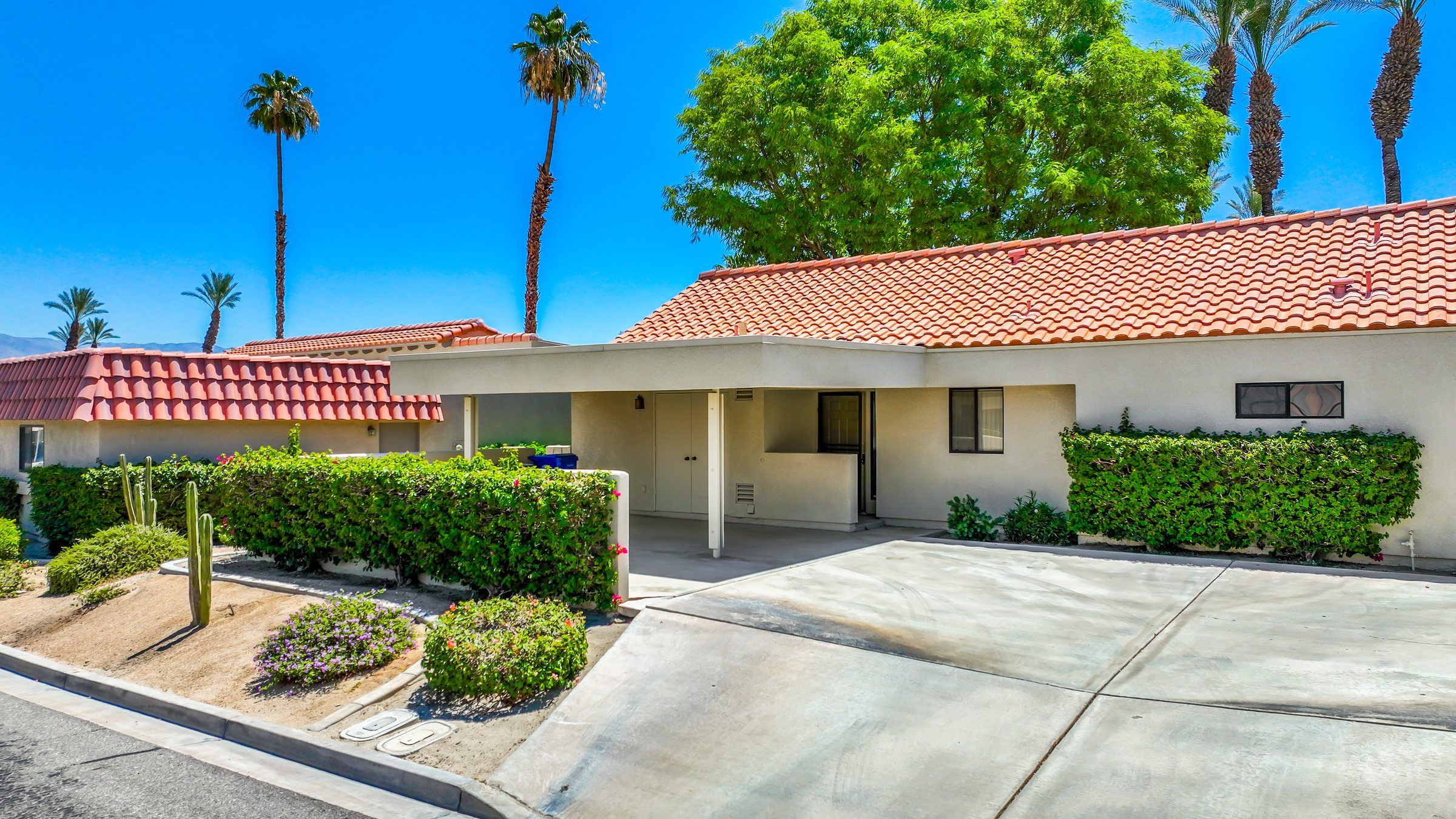 Street view of 41726 Resorter Blvd, Palm Desert — a single-story Mediterranean condominium with a red tile roof and desert landscaping