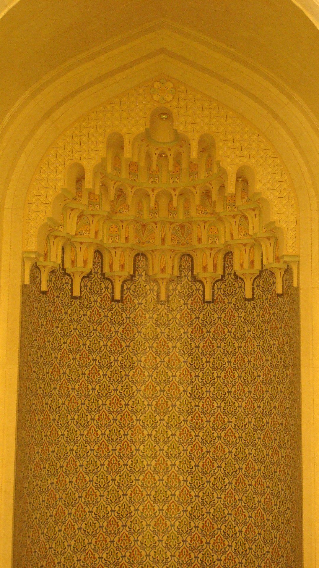 Vertical decorative wall niche with layered muqarnas detailing and patterned surface