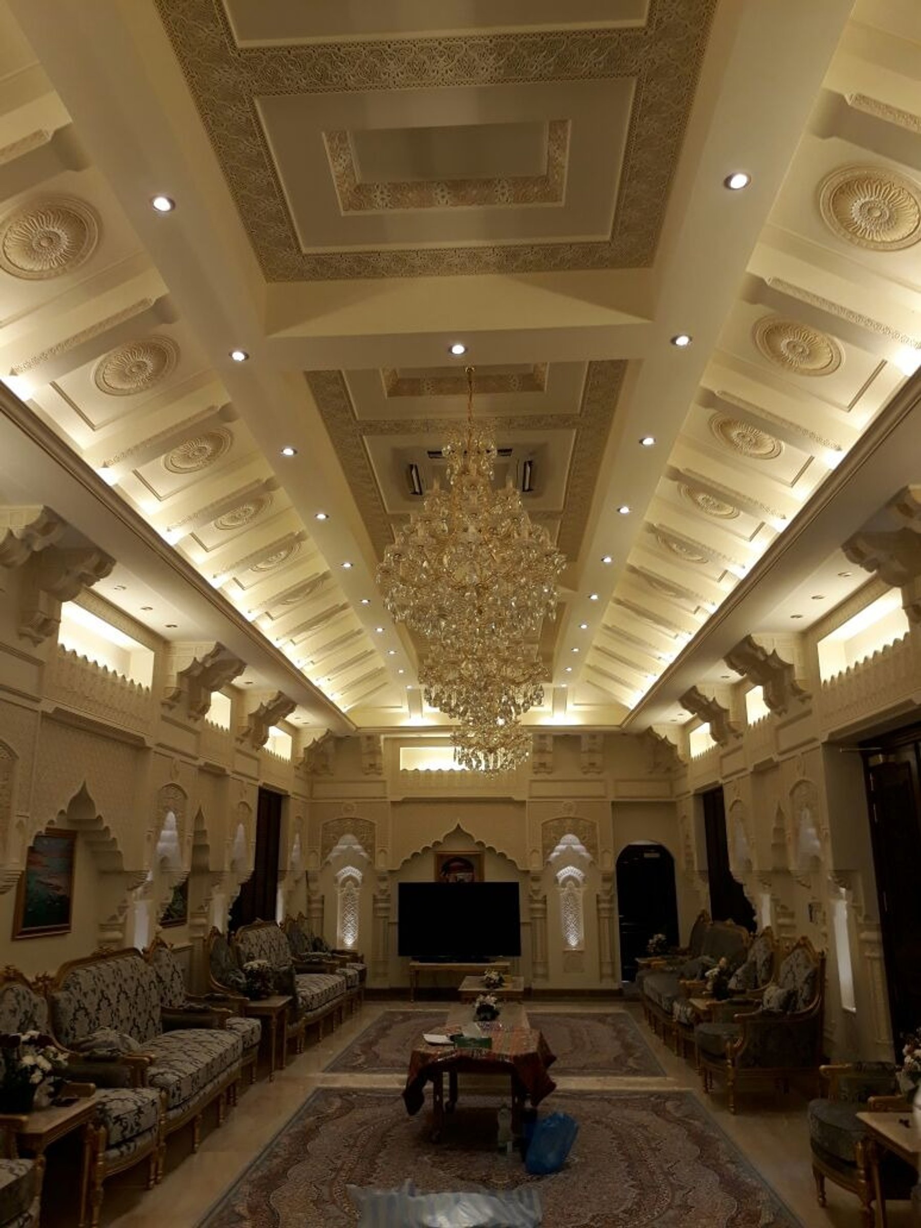 Long ceremonial seating hall with layered ceiling details and central chandeliers