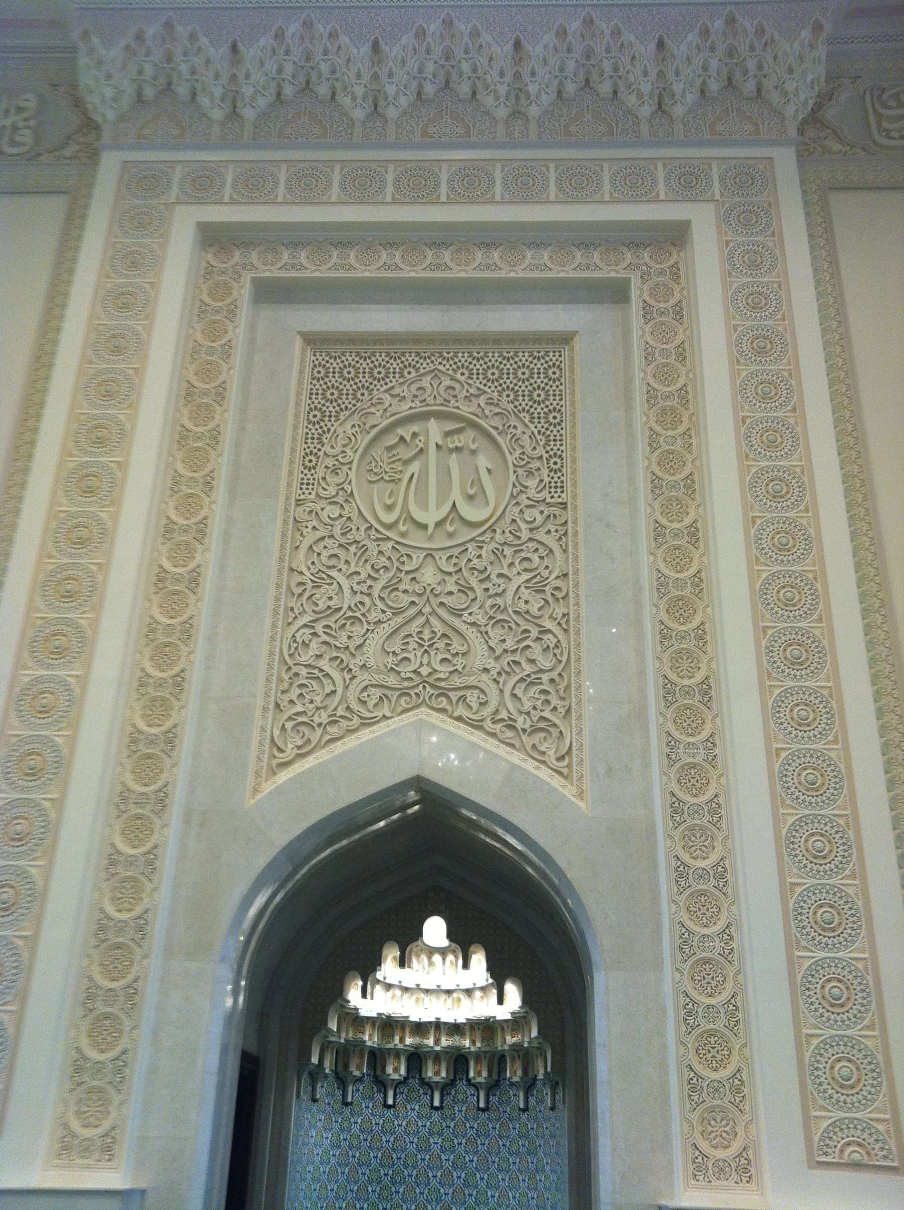 Decorative gypsum arch and calligraphic detailing inside an Oman mosque