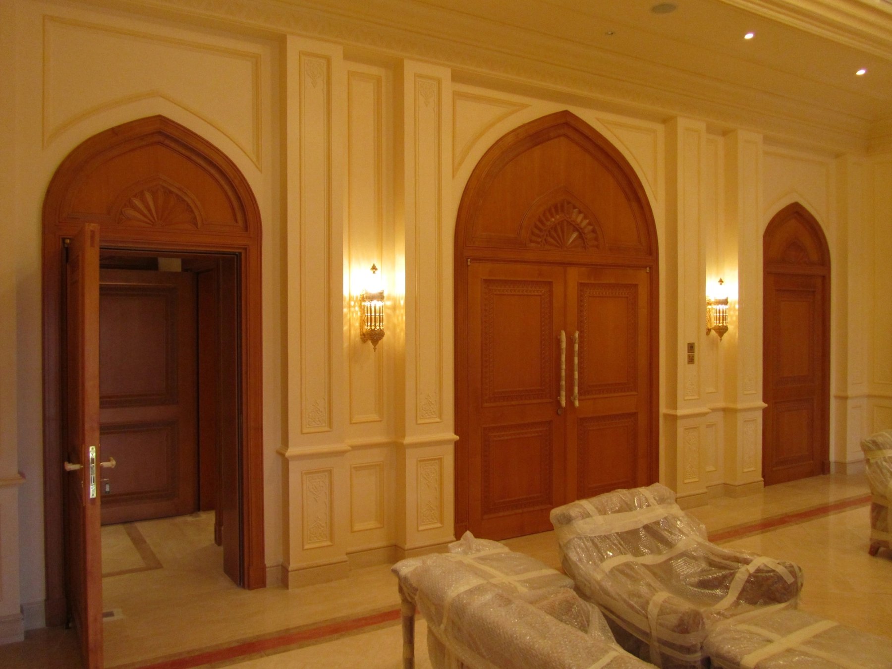 Arched timber doors integrated within decorative interior wall paneling
