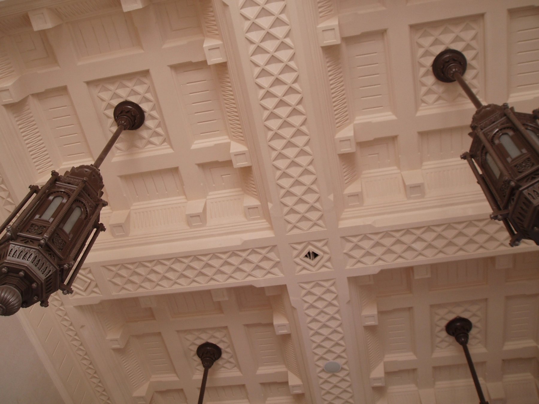 Detailed geometric ceiling relief with suspended decorative lanterns