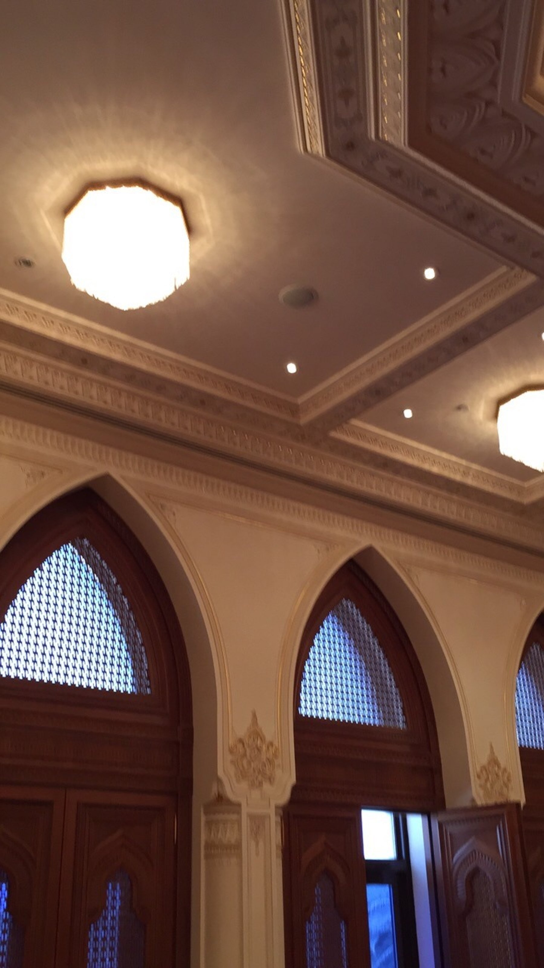 Tall timber door surrounds beneath ornate interior ceiling details