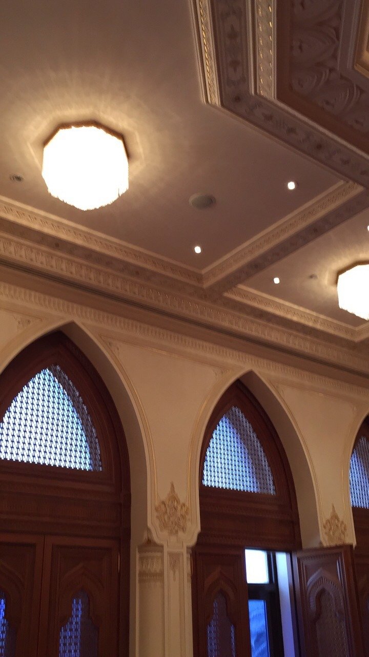 Tall timber door surrounds beneath ornate interior ceiling details