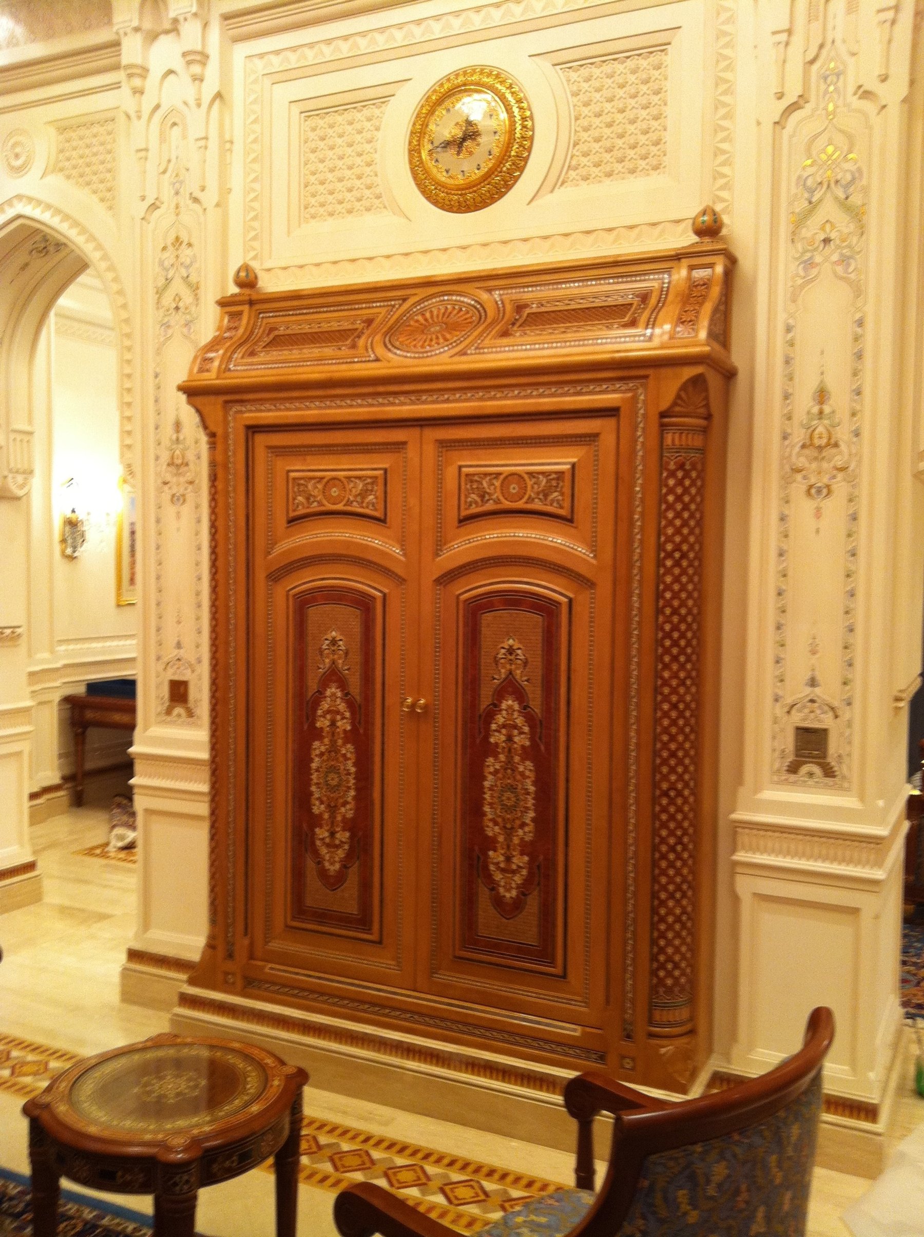 Bespoke carved timber cabinet integrated within an ornate interior wall