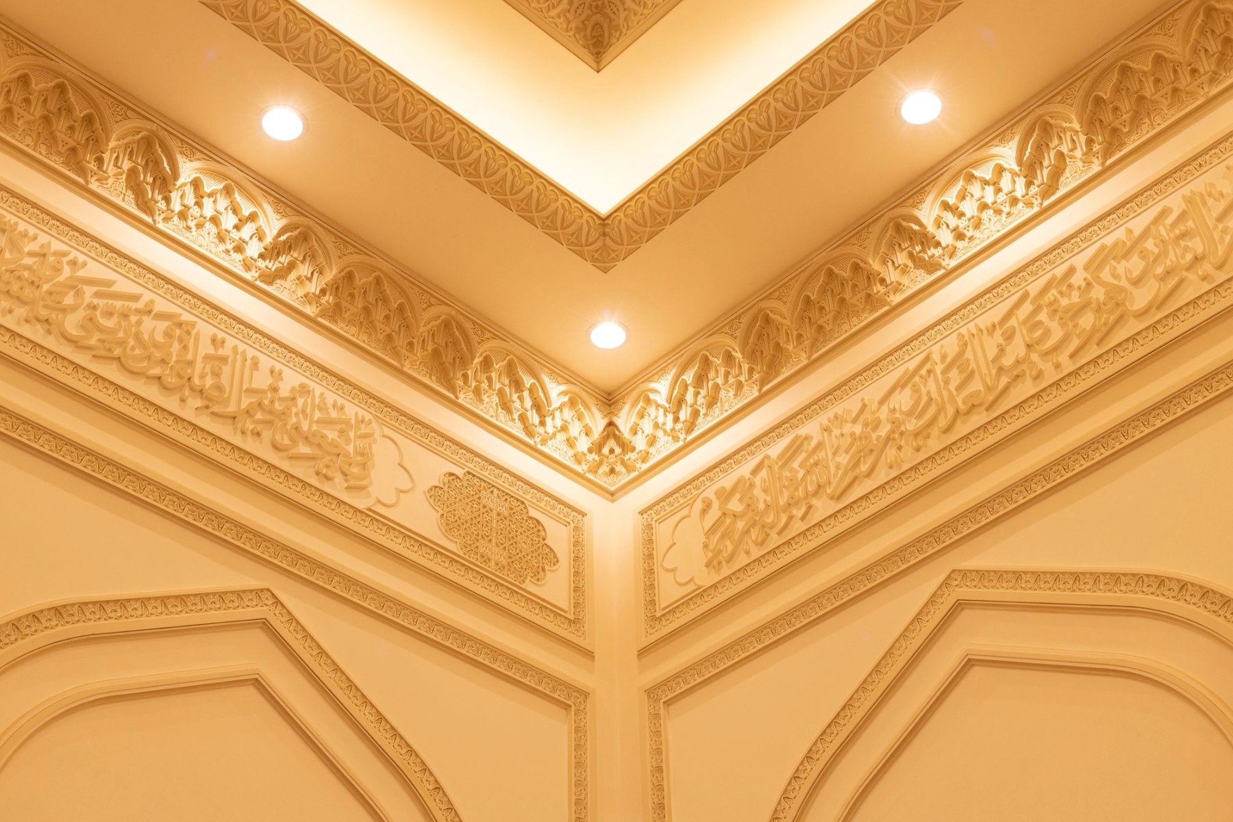 Close architectural detail of decorative gypsum cornice and illuminated ceiling recess