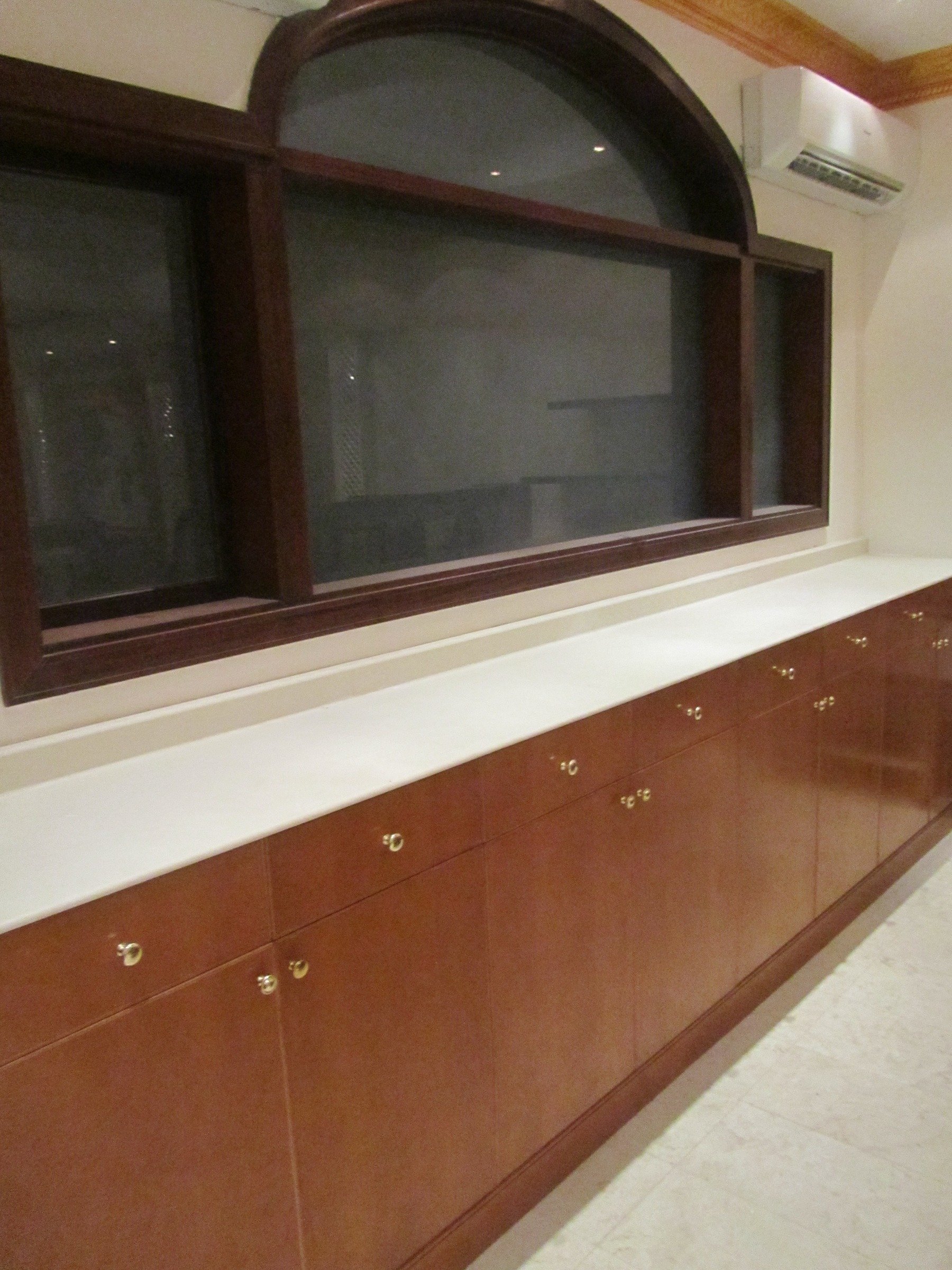 Built-in timber cabinetry beneath a large arched interior opening