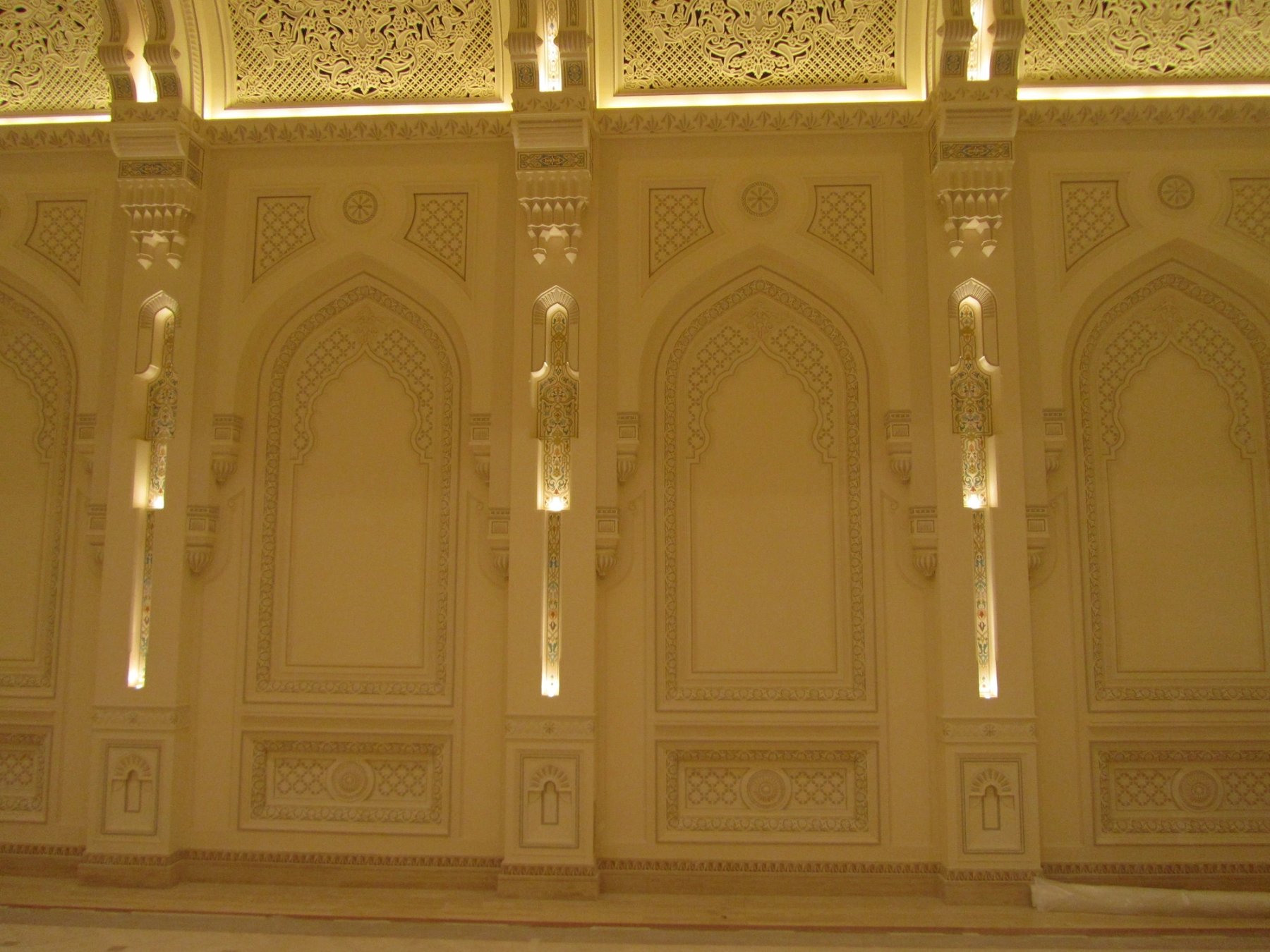Illuminated decorative wall panels with carved arches and intricate surface detailing