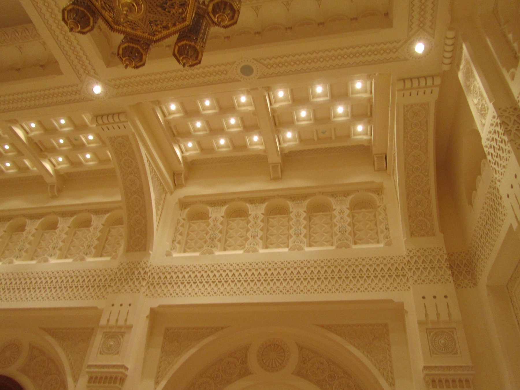 Detailed ornamental ceiling and upper wall treatments in a private majlis