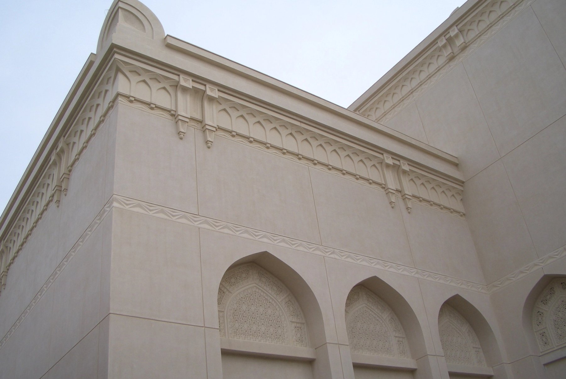 Architectural exterior with layered GRC cornice, pointed arches and decorative facade panels