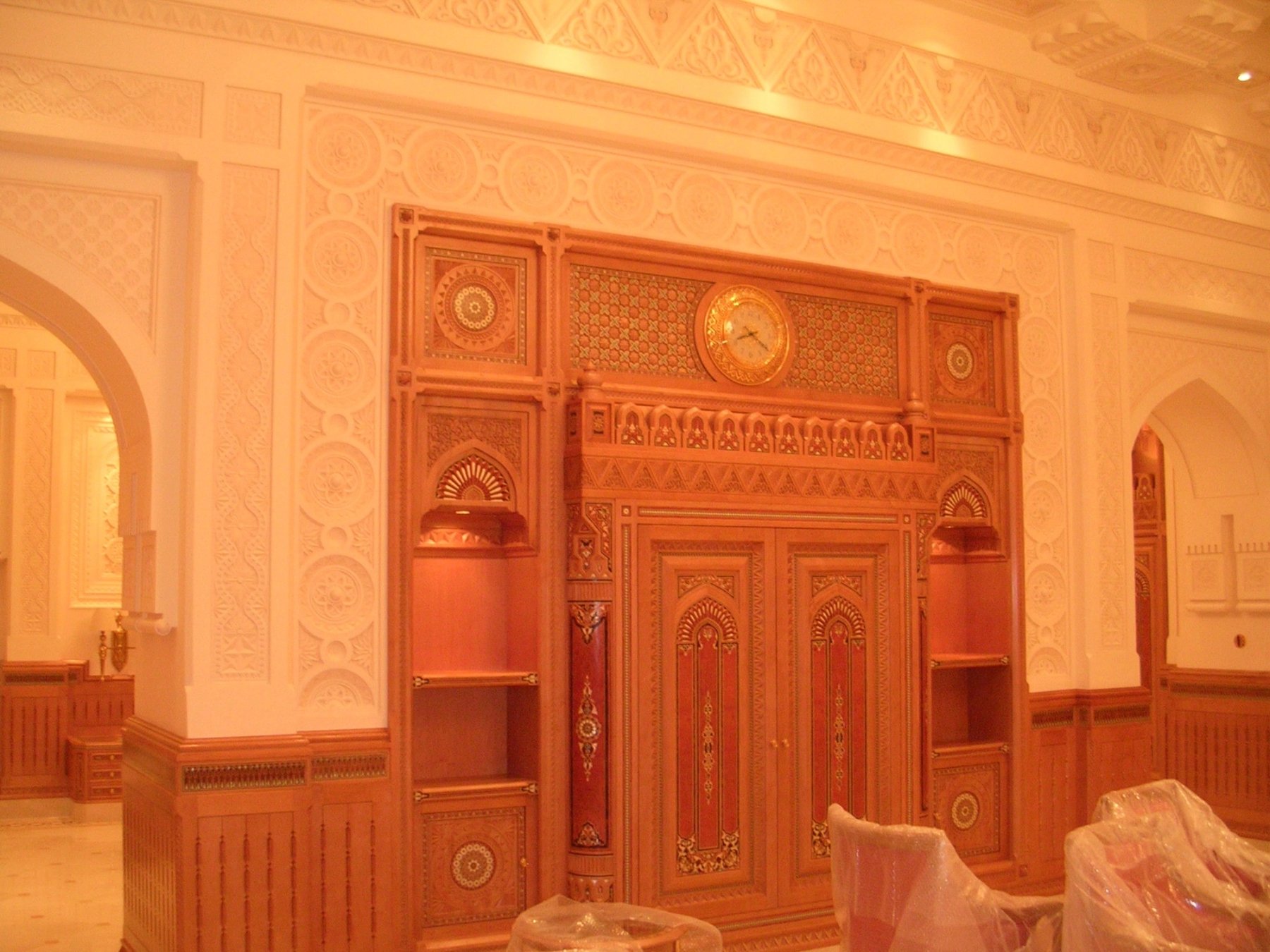 Carved timber double doors framed by richly detailed interior wall finishes