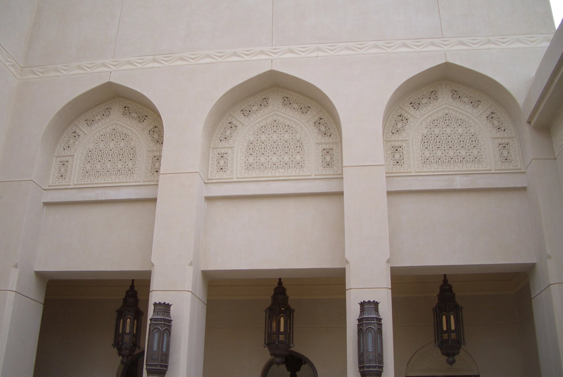 Arched GRC screens with intricate perforated detailing above exterior openings