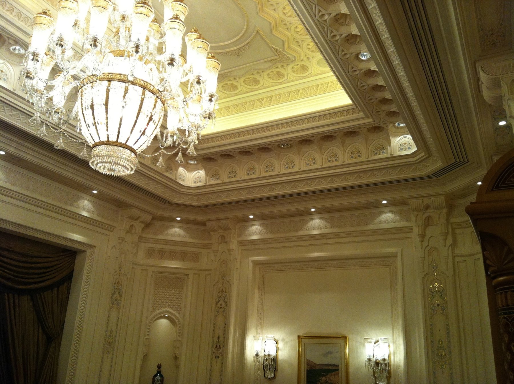 Decorative coffered ceiling with chandelier and illuminated architectural detailing