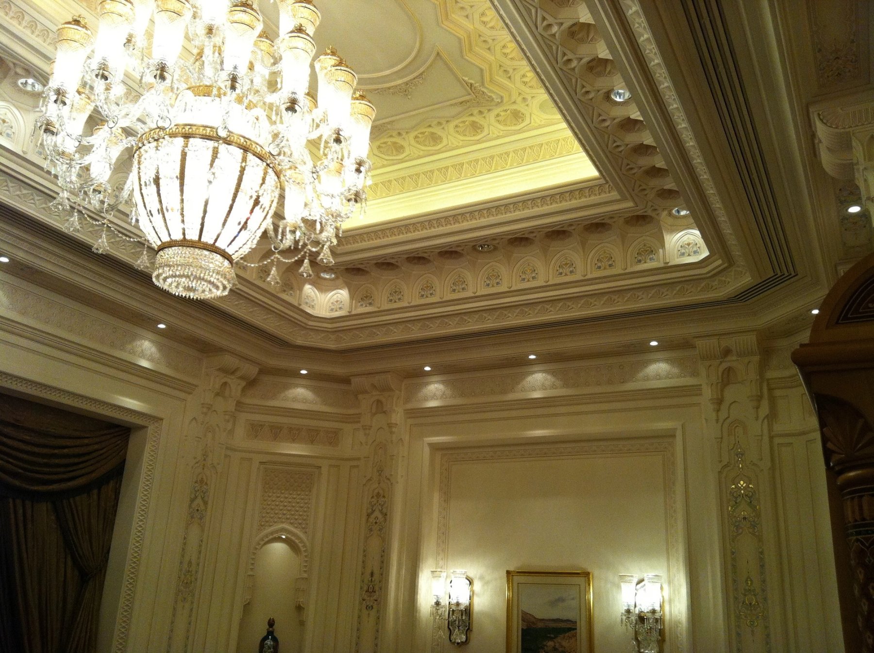 Decorative coffered ceiling with chandelier and illuminated architectural detailing