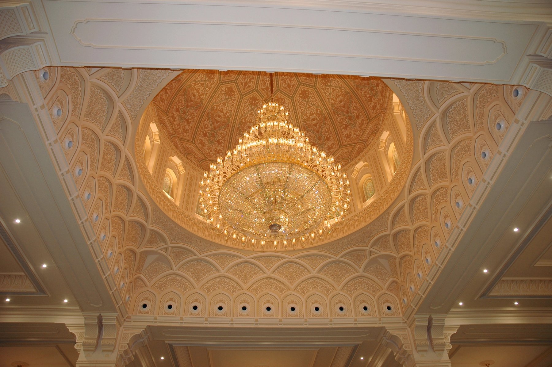 Decorative ceiling dome with large chandelier and intricate gypsum ornamentation