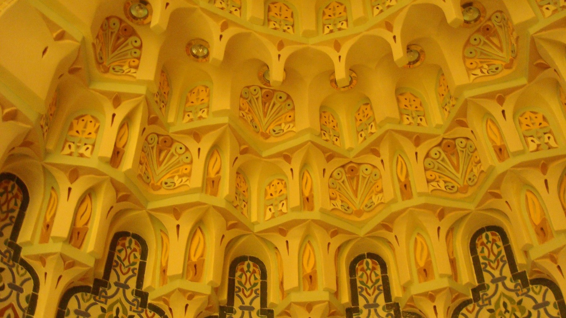 Close-up of layered muqarnas ornament with painted geometric accents