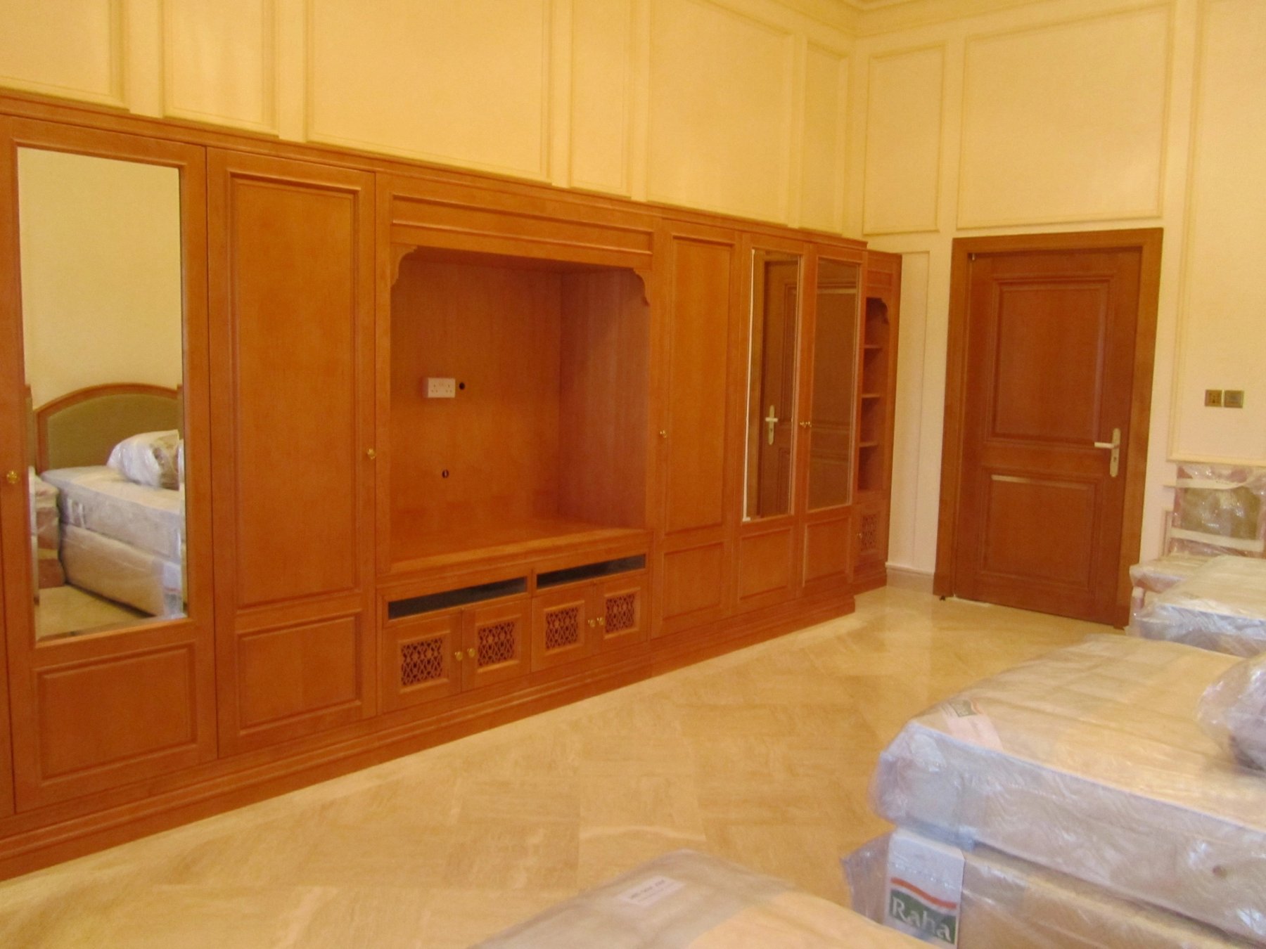 Bespoke full-height timber media and storage cabinetry in a private room