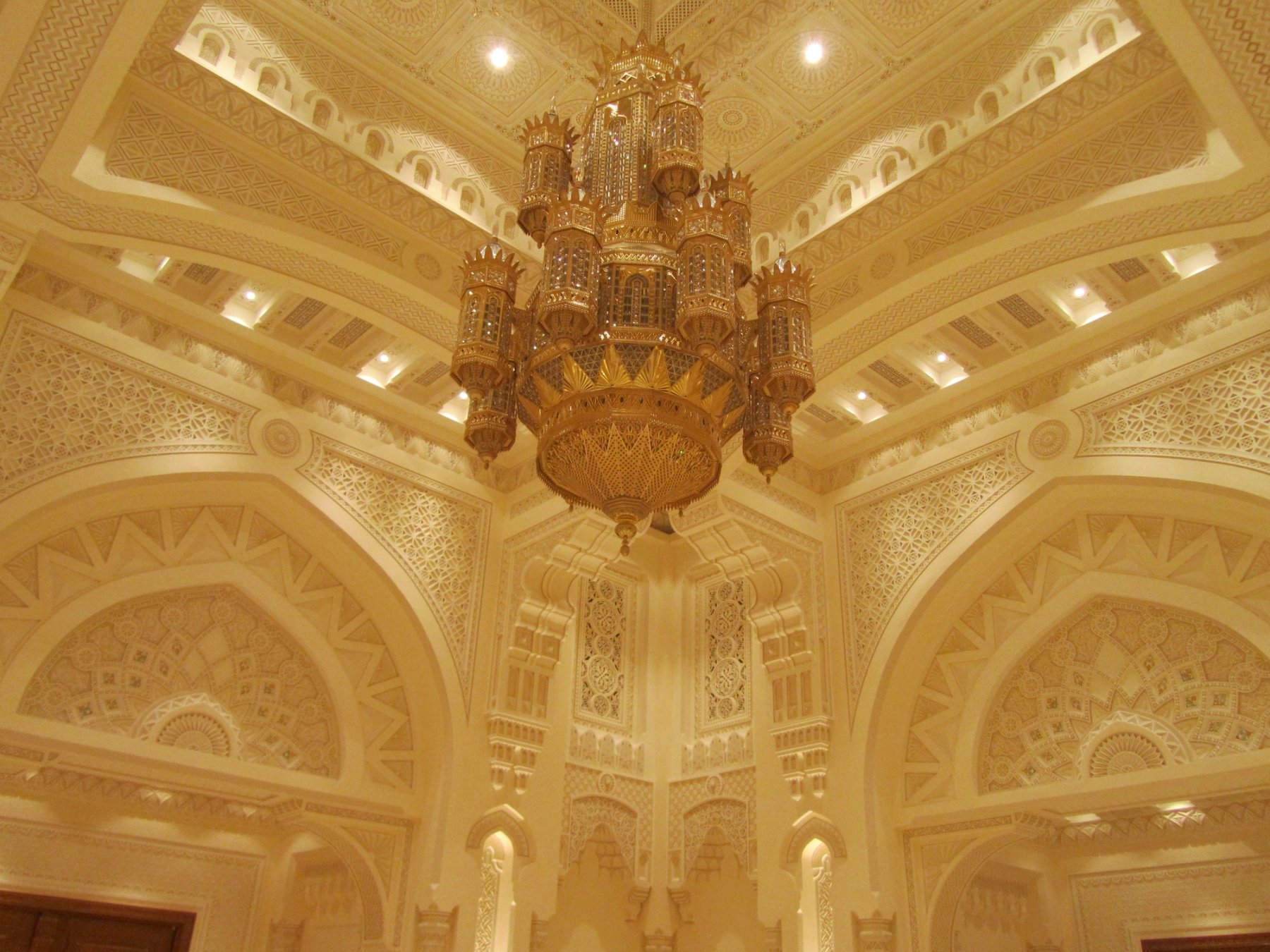 Grand cultural interior with chandelier, carved arches and layered architectural detailing