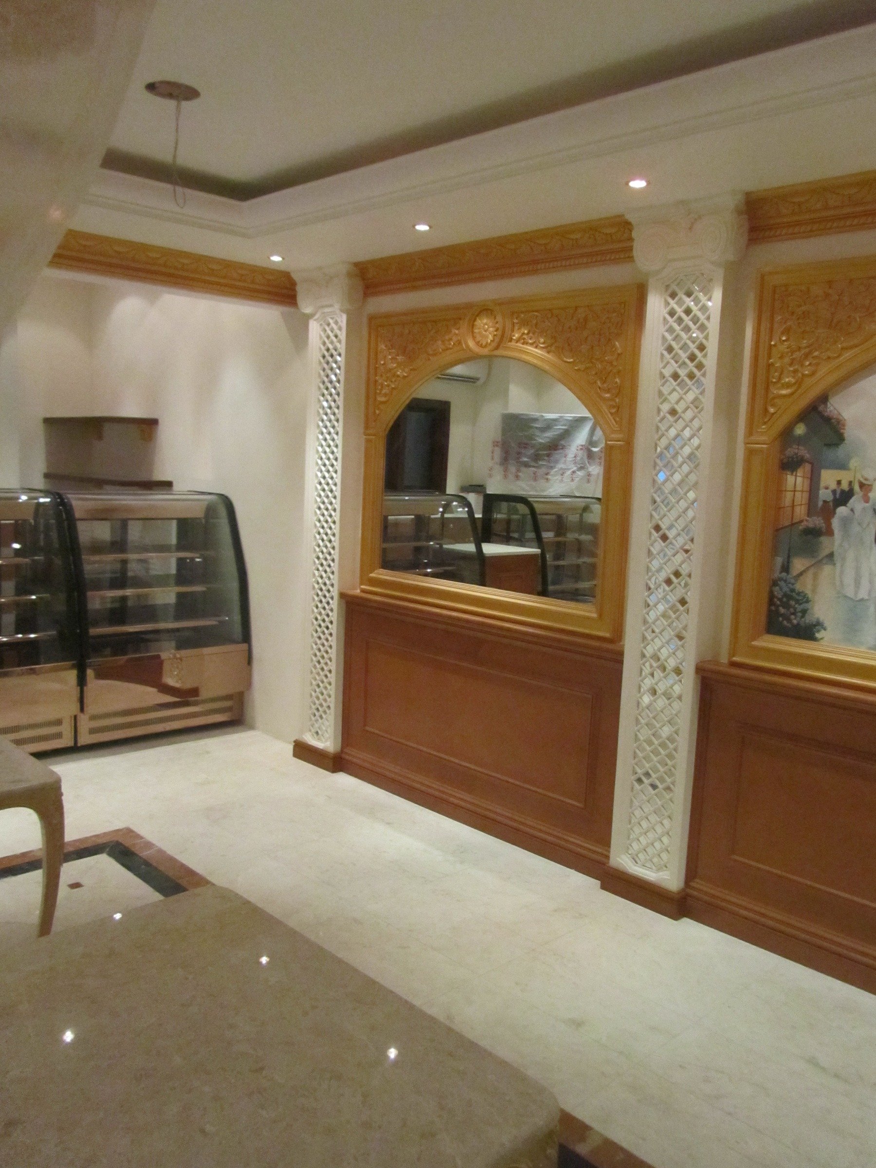 Restaurant interior wall with carved timber arch, lattice detailing and display counter