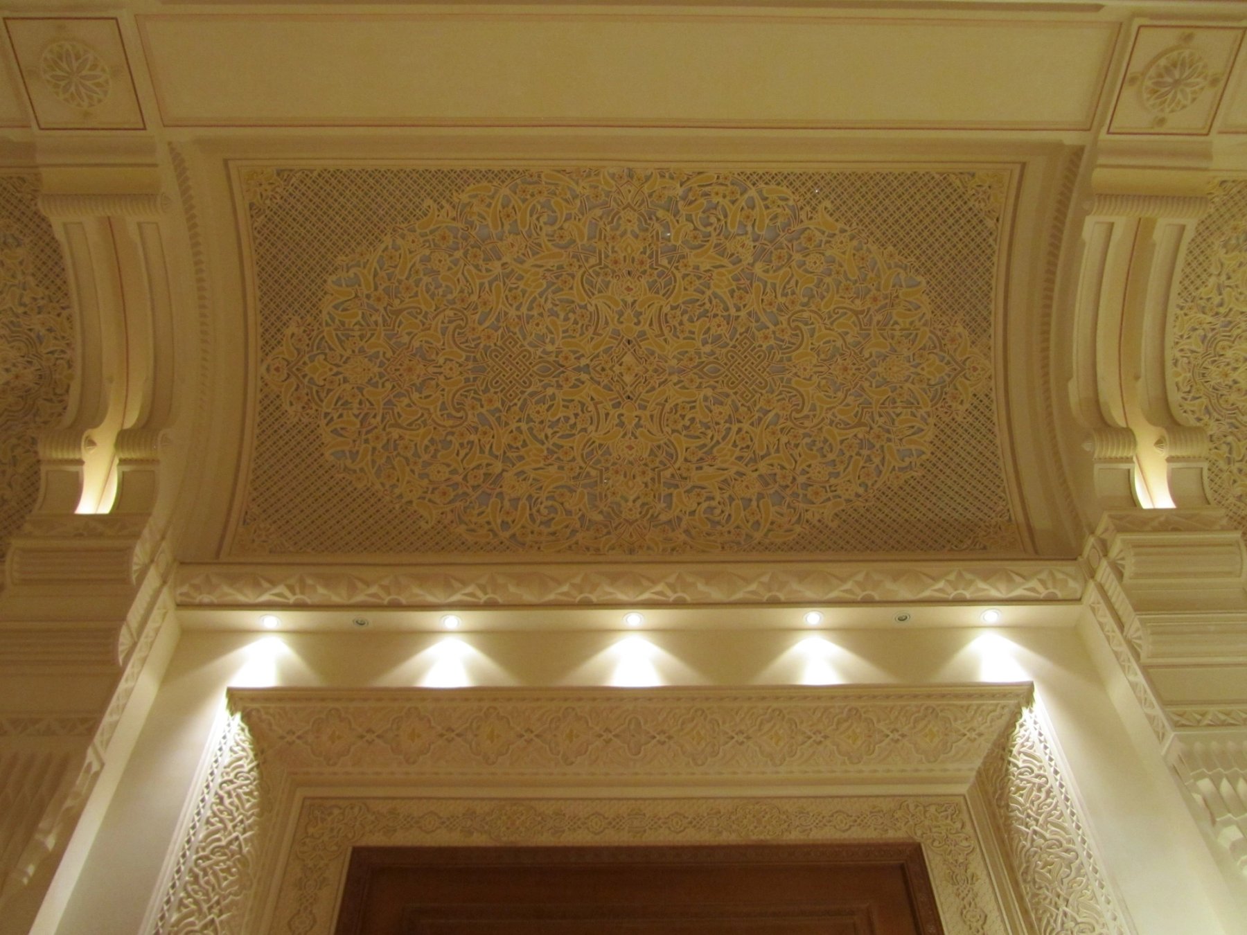 Ornamental wall panel above a timber doorway with concealed architectural lighting