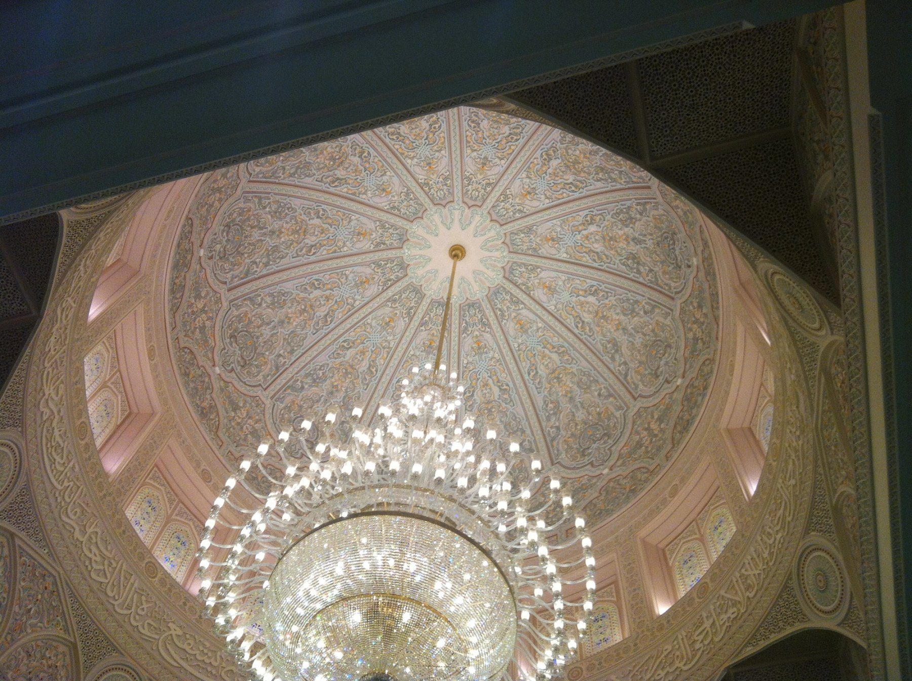 Domed ceiling with chandelier, carved borders and detailed interior ornamentation