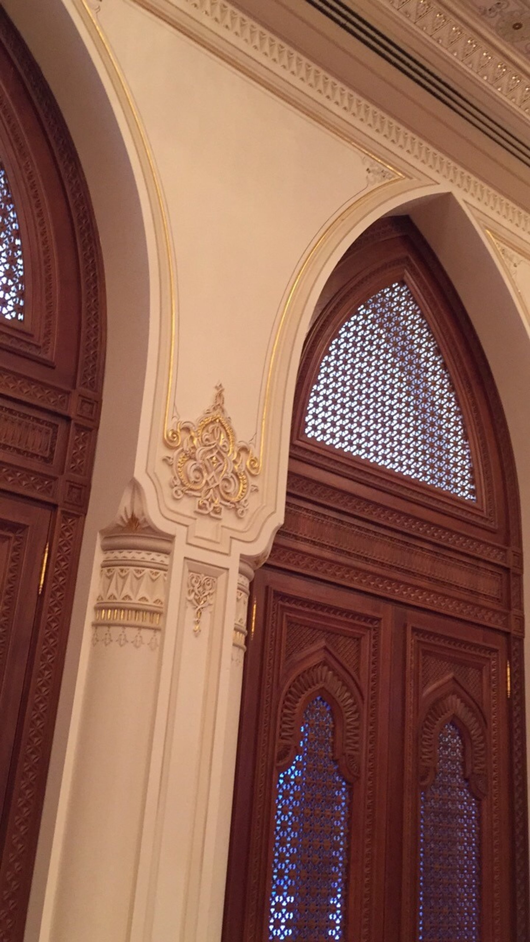 Carved timber doors framed by arched decorative wall detailing