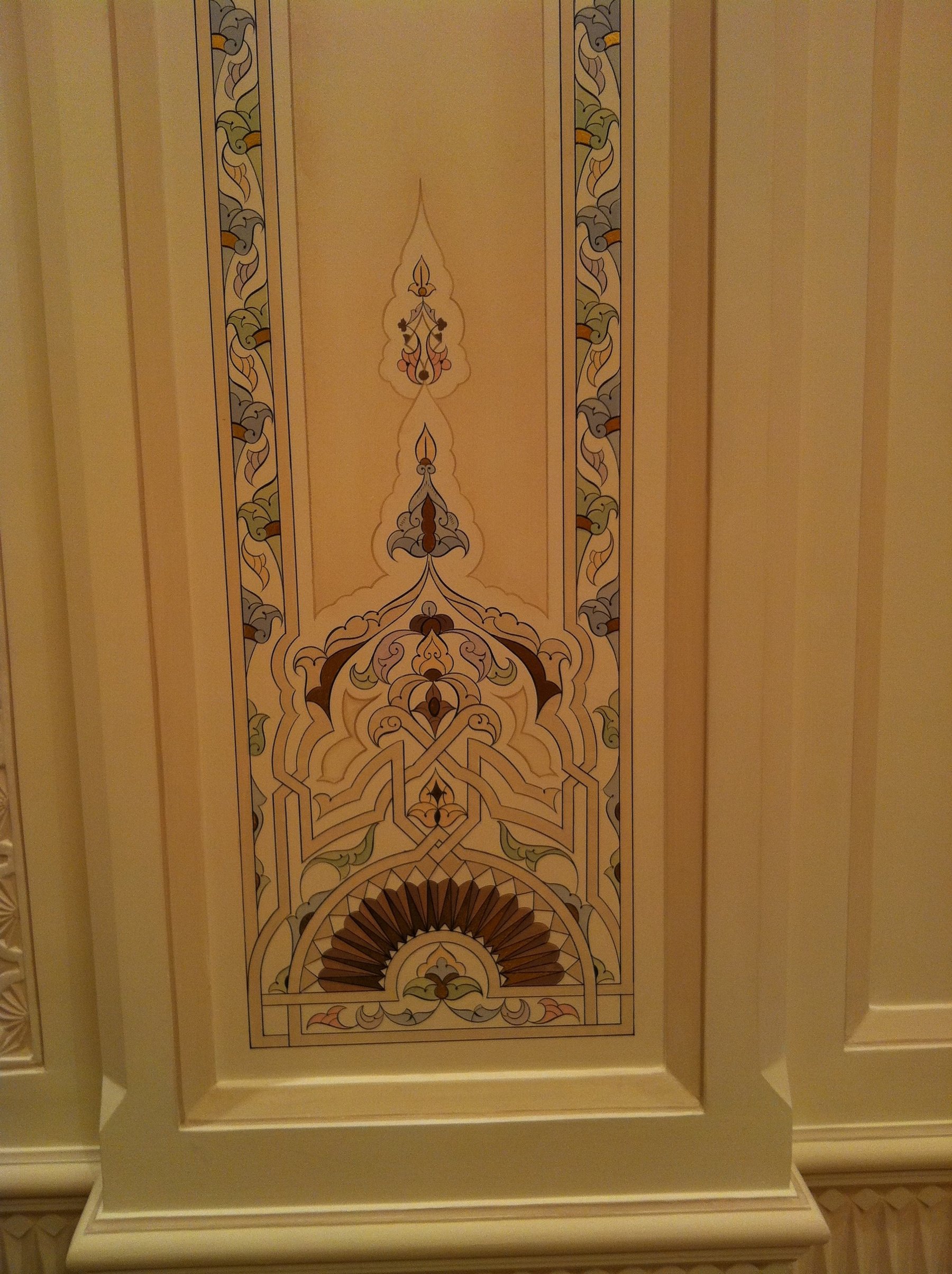 Hand-painted ornamental wall panel framed by decorative molding