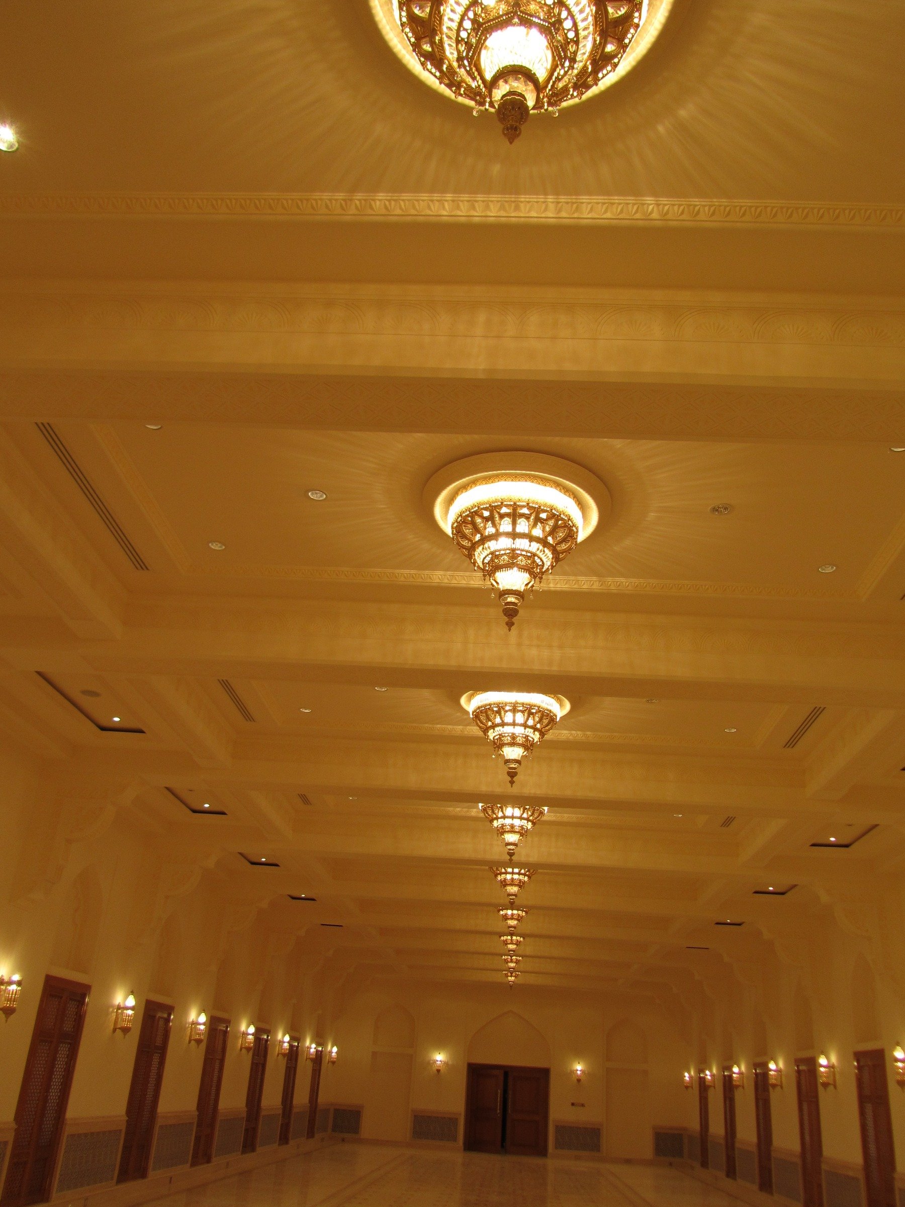 Ceiling and lighting rhythm extending through a large private interior hall