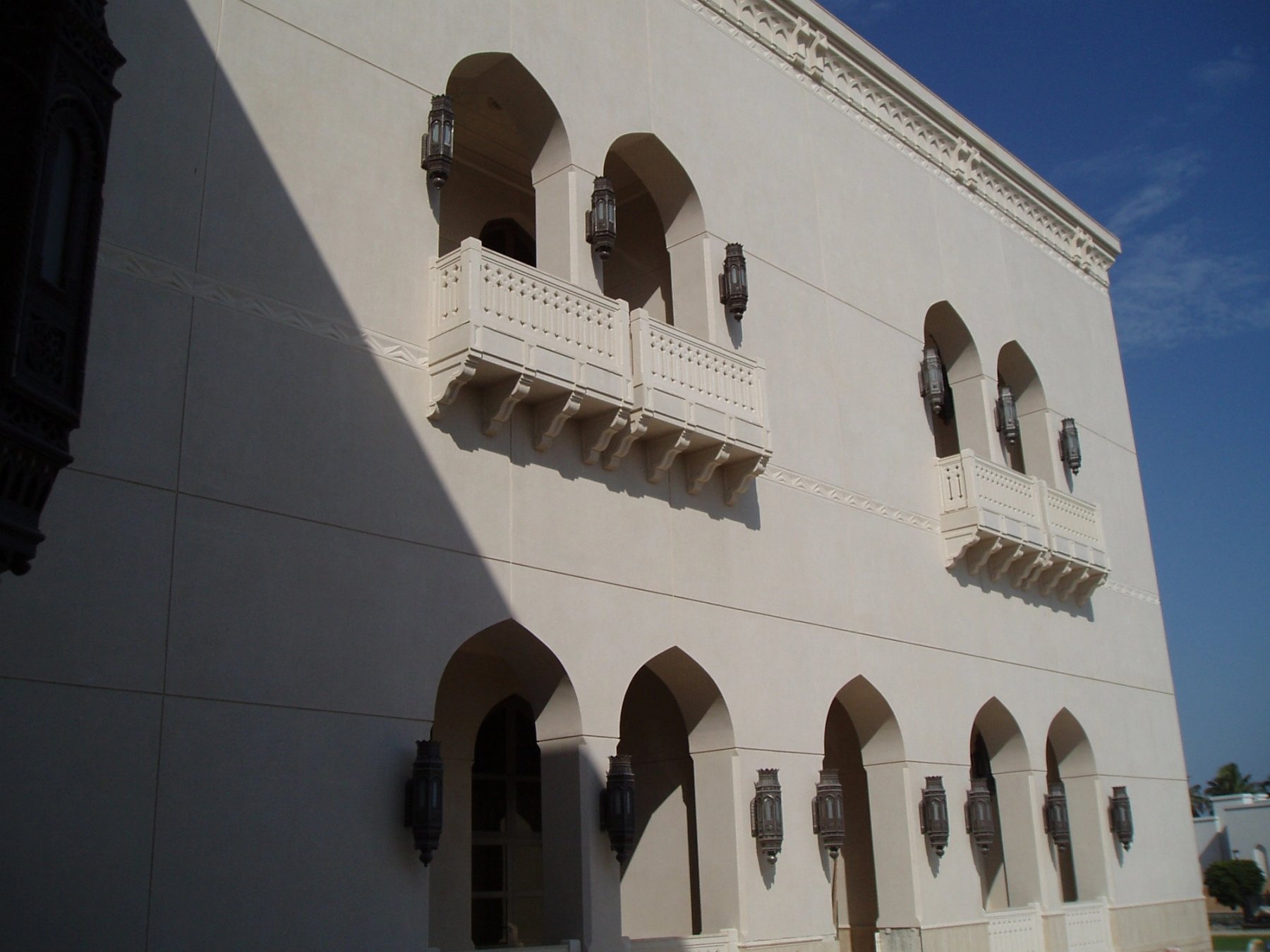 Exterior facade with repeated pointed arches, balconies and decorative architectural lanterns