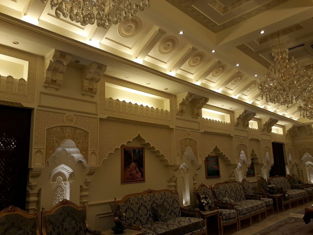 Formal seating area with decorative wall panels, carved arches and chandelier lighting