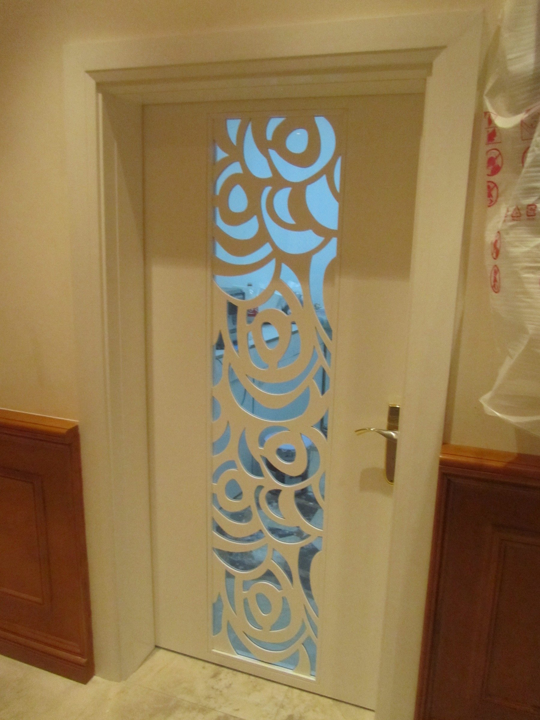 Custom interior door with floral cut-out panel and integrated timber wall panelling